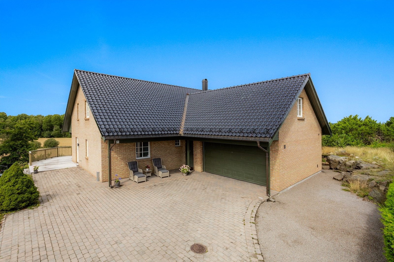 Parkering på egen tomt med belegningsstein og i integrerte dobbeltgarasje. Det er montert elbillader i garasjen. Galleribilde