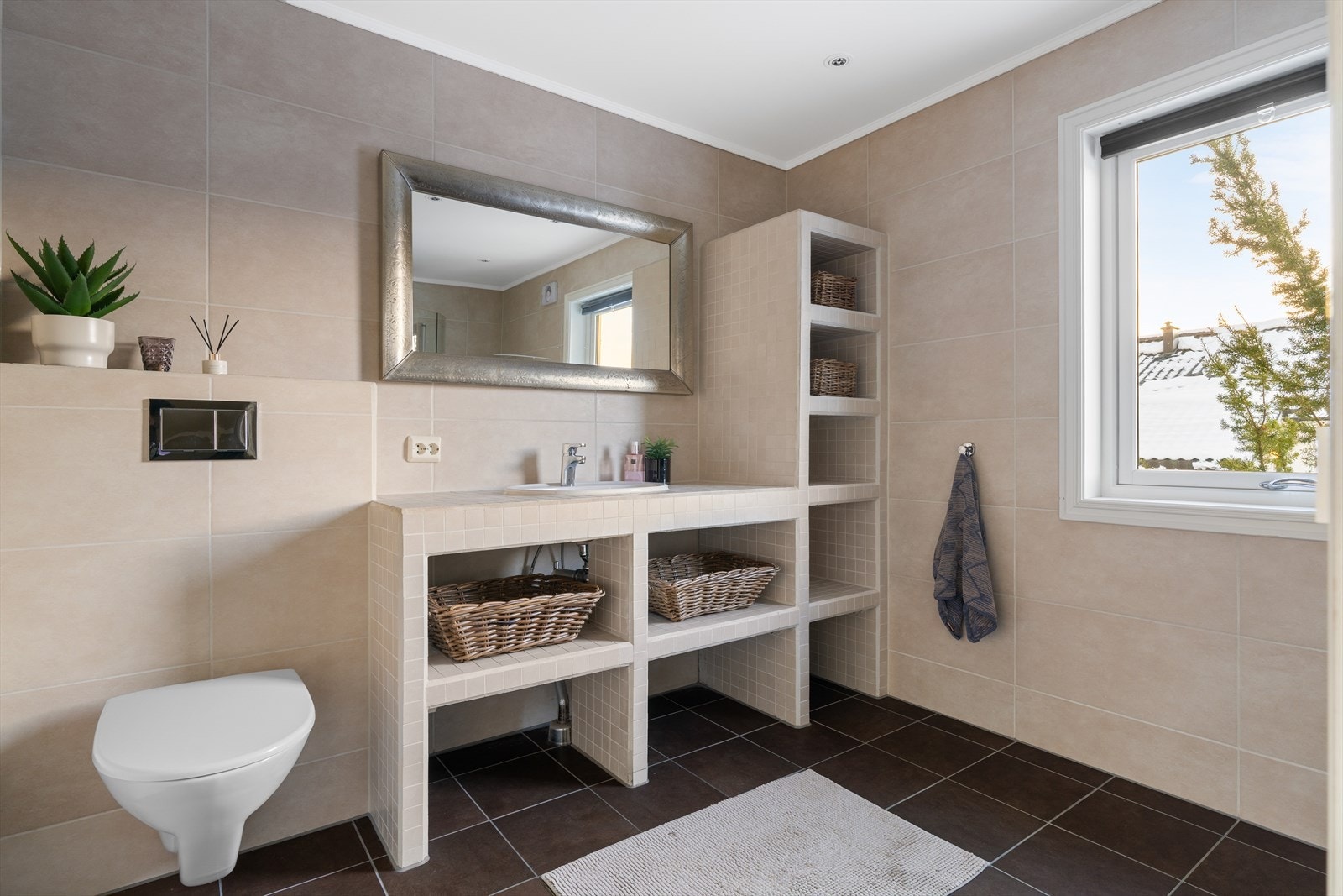 Badet fremstår som romslig og gjennomført med helhetlig materialbruk. Galleribilde