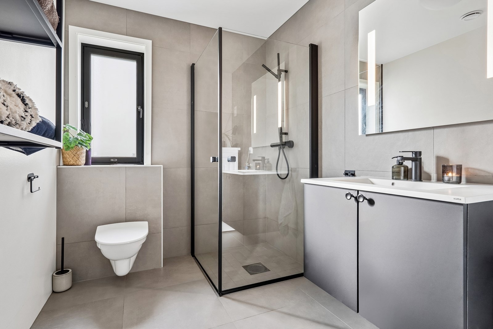 Lekkert bad med store fliser, vegghengt toalett og innfellbare dusjvegger Galleribilde