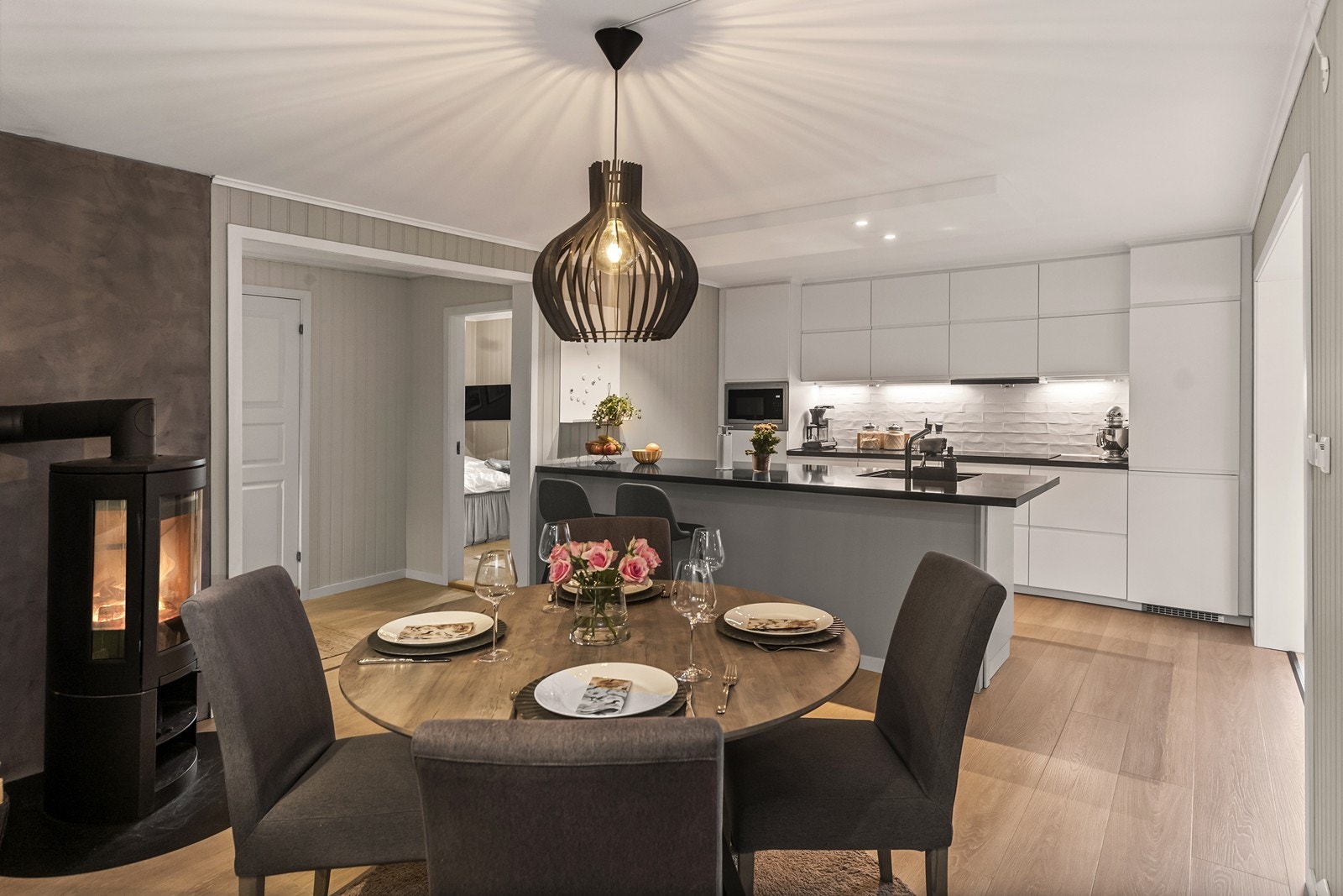 Kjøkken og spisestue er et sosialt samlingspunkt, med en moderne peisovn fra 2022. Galleribilde