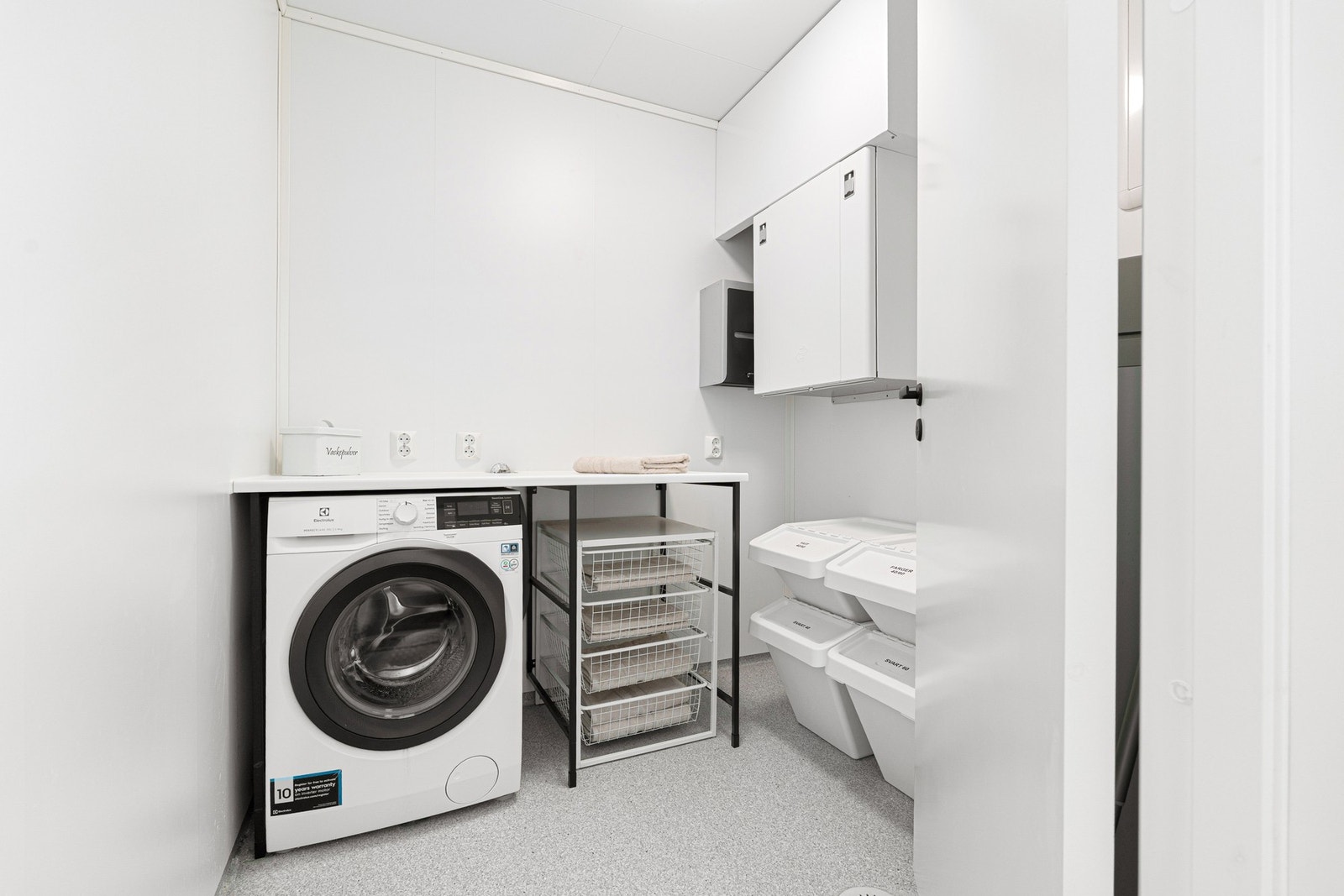 Praktisk vaskerom med opplegg for vaskemaskin, baderomsmøblement og skap. Inntegnet som bod, men alltid brukt som vaskerom Galleribilde