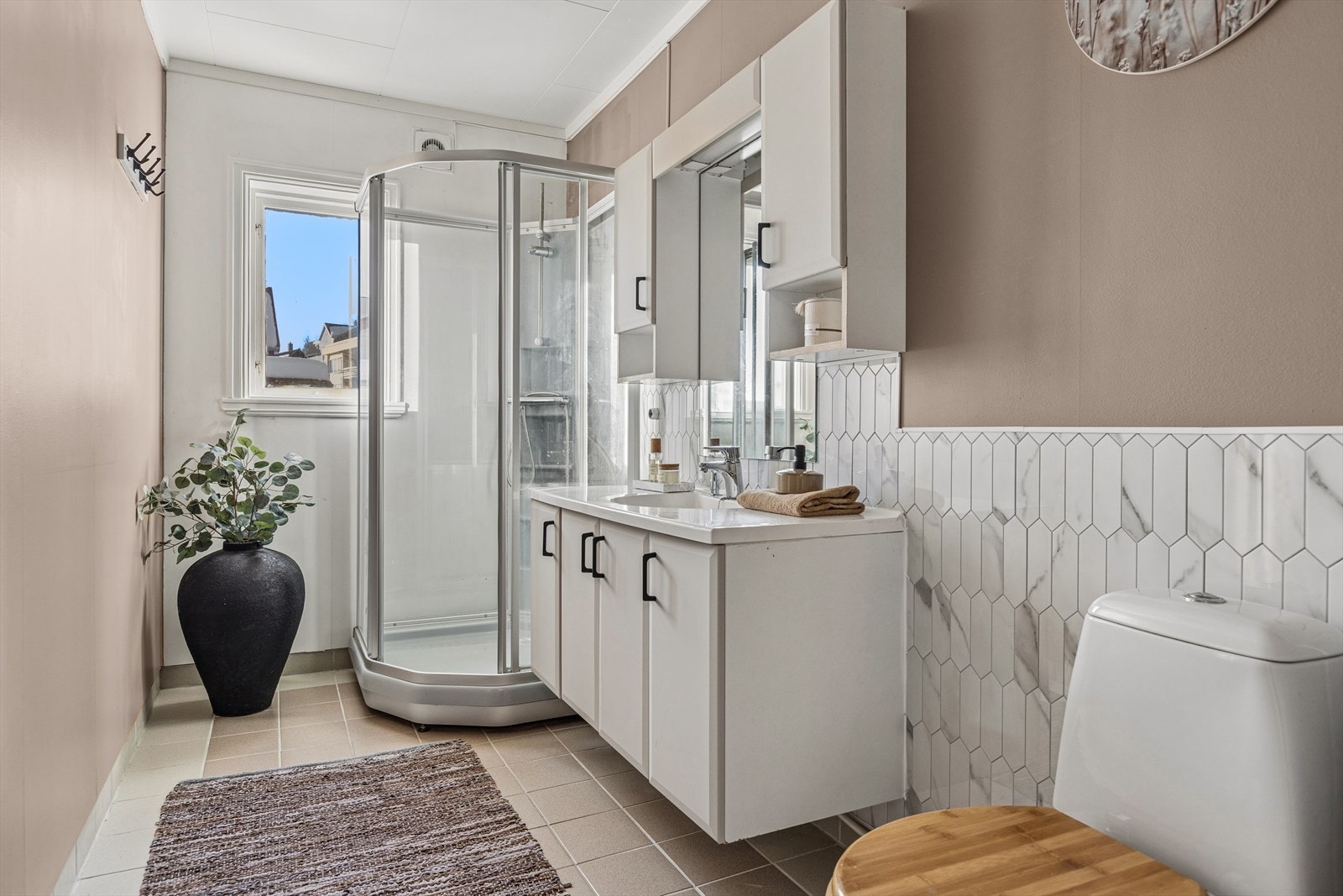 Innbydende og lunt baderom med praktisk dusjkabinett. Galleribilde