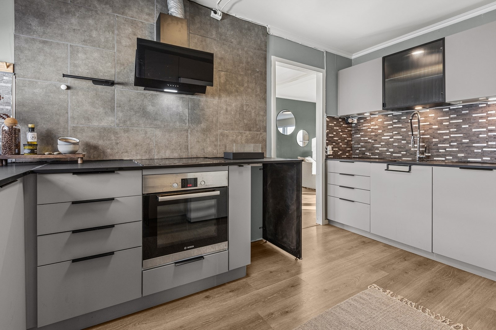 Praktisk hjørnekjøkken med slette fronter i grå utførelse. Galleribilde