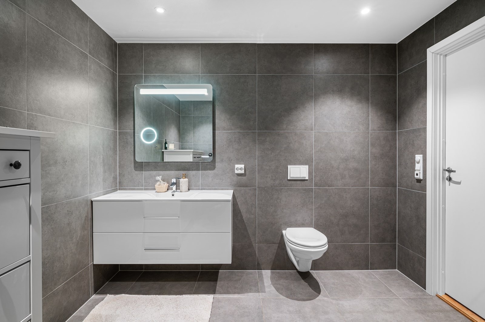 - Badet er innredet med vegghengt toalett, heldekkende servant og dusjdører i glass - Galleribilde