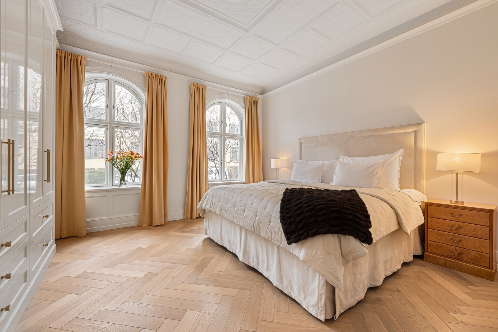 Romslig hovedsoverom med god takhøyde, dekorativ himling og klassisk fiskebensparkett. Galleribilde