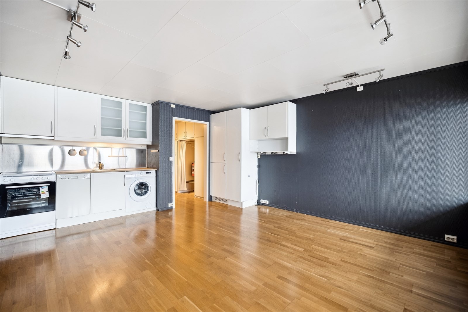 Enkel kjøkkeninnredning med plass for frittstående komfyr. Integrert kjøleskap. Galleribilde