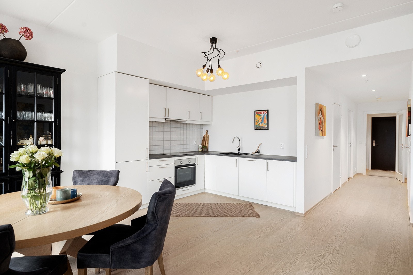 Lekkert kjøkken med innredning i moderne utførelse med slette fronter og integrerte hvitevarer. Galleribilde