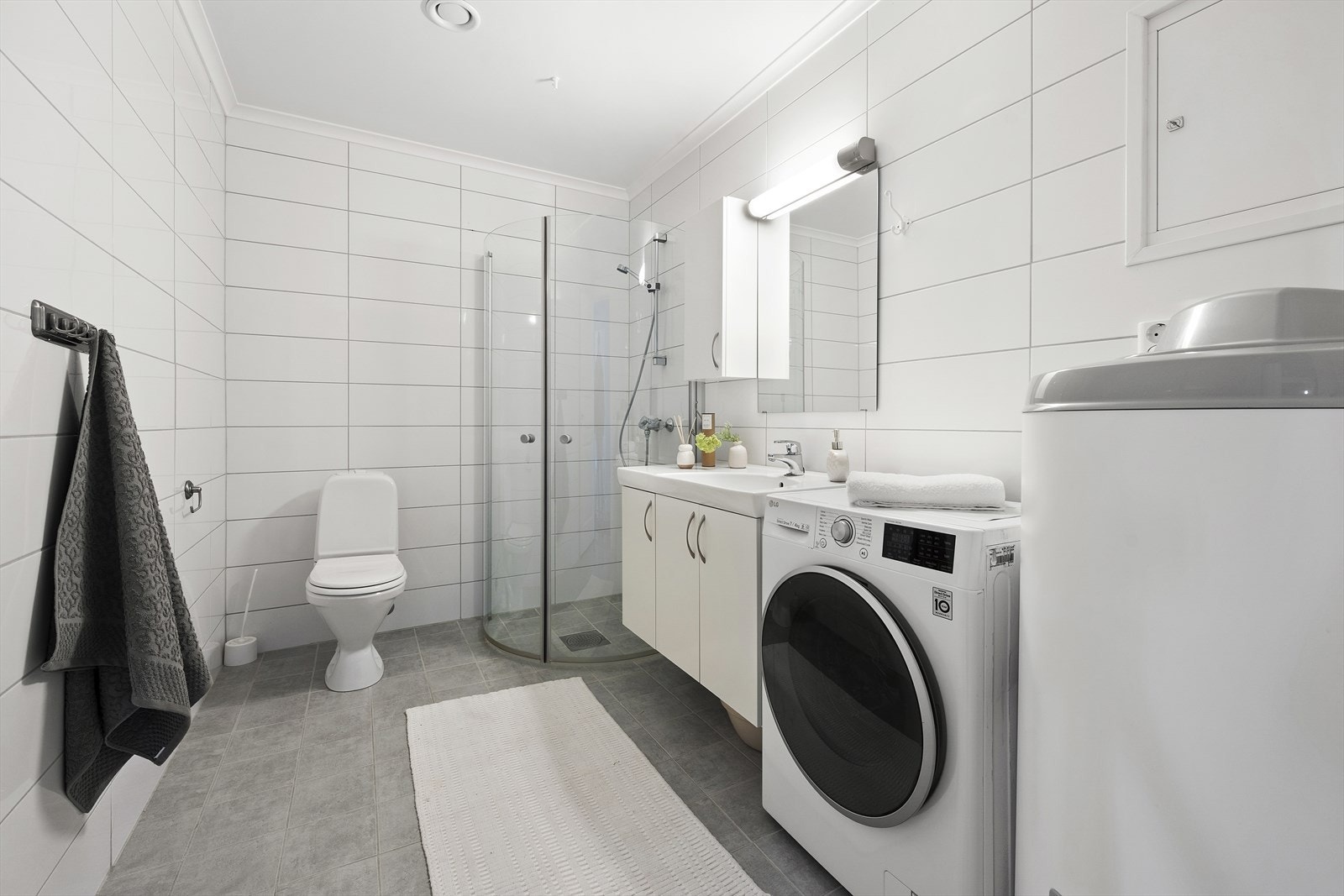 Bad med toalett og opplegg for vaskemaskin Galleribilde