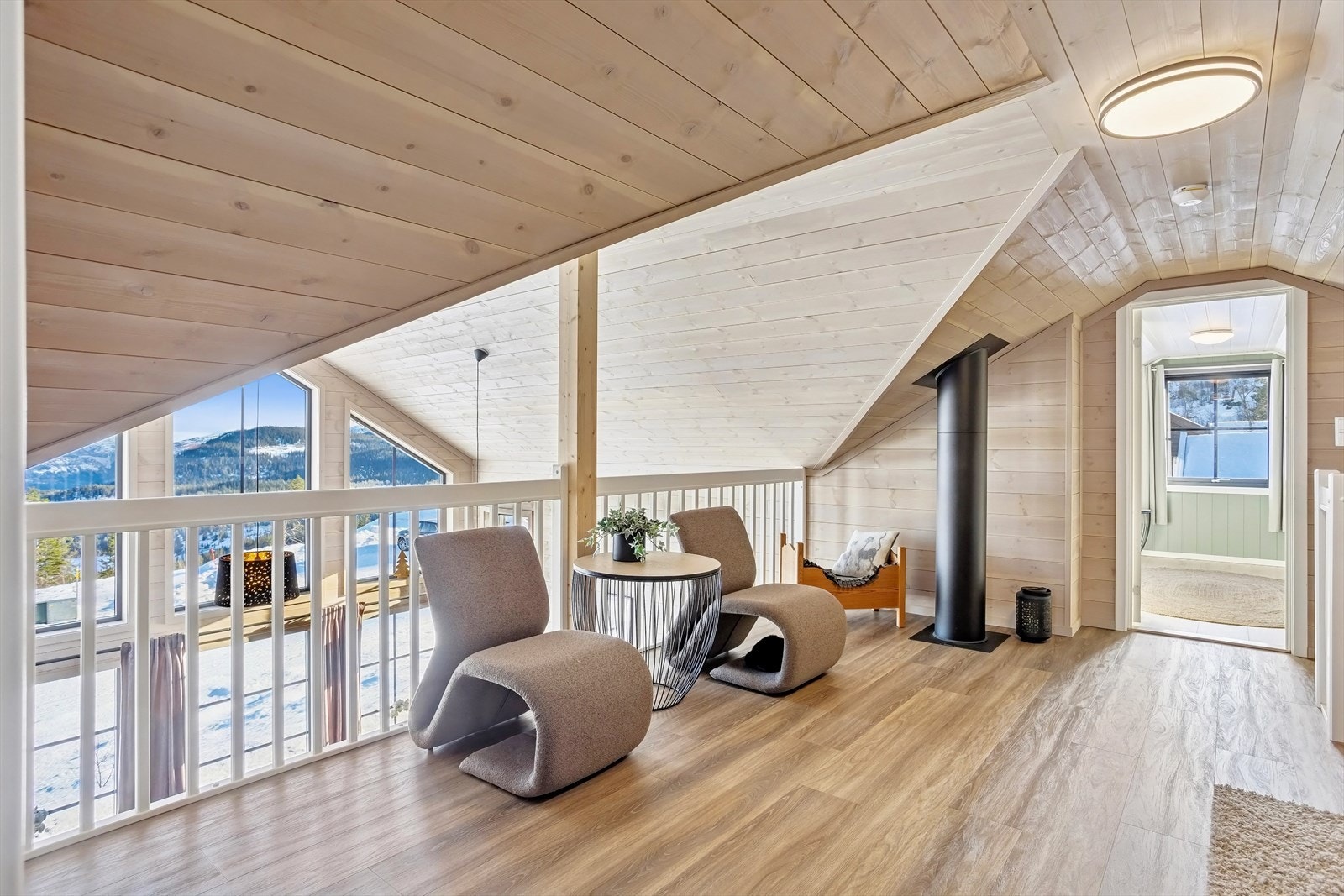 Lys og åpen loftstue med luftig utsyn ned mot stuen Galleribilde