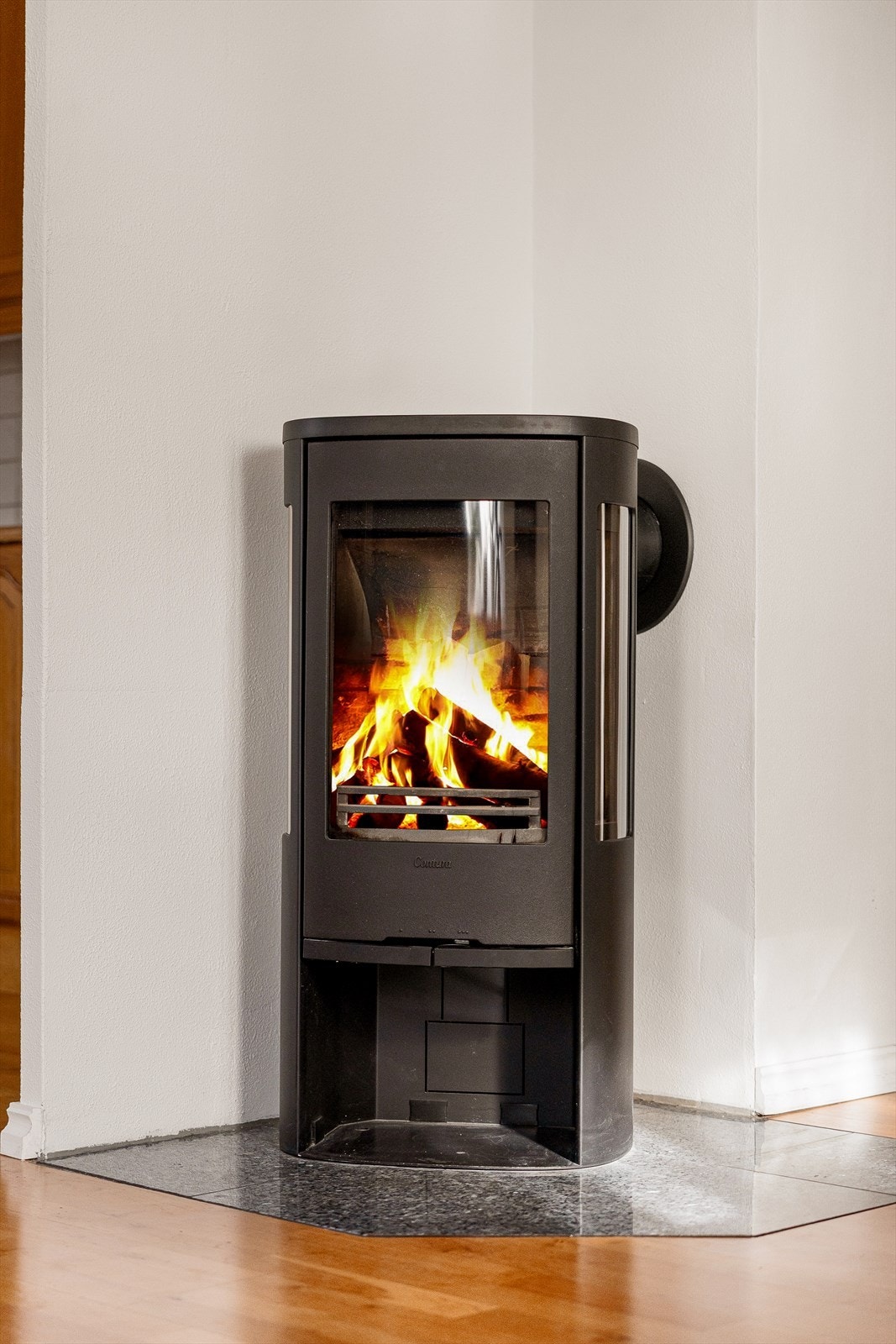 Sentralt plassert i rommet finnes en varmende vedovn som varmer godt på litt kaldere vinterdager. Galleribilde