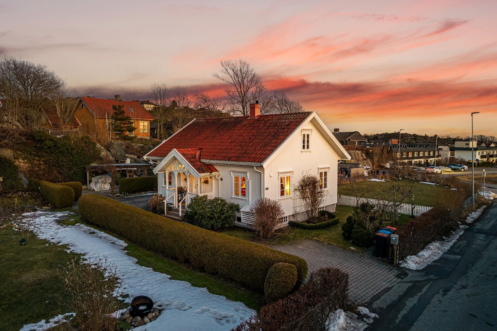 Tomten har en romslig gårdsplass belagt med belegningsstein, omkranset av velstelte hekker som skaper et skjermet og hyggelig miljø. Galleribilde