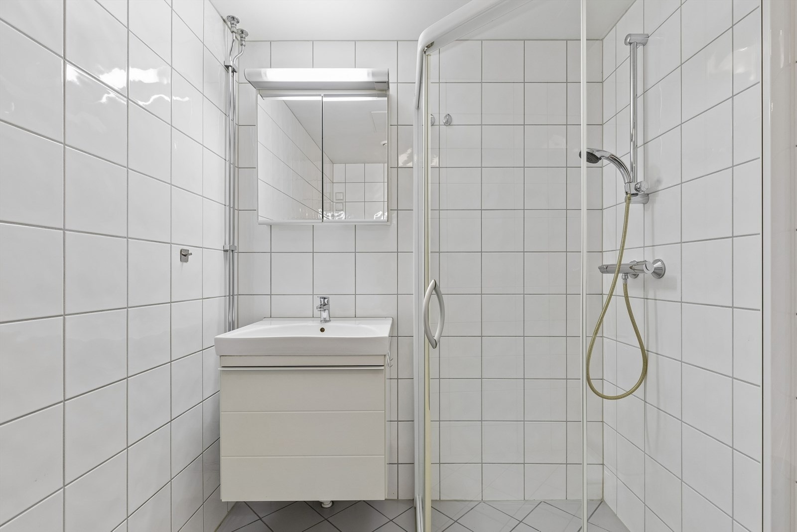 Innredningen består av servantskap, dusjhjørne med skyvedører og gulvstående toalett. Galleribilde