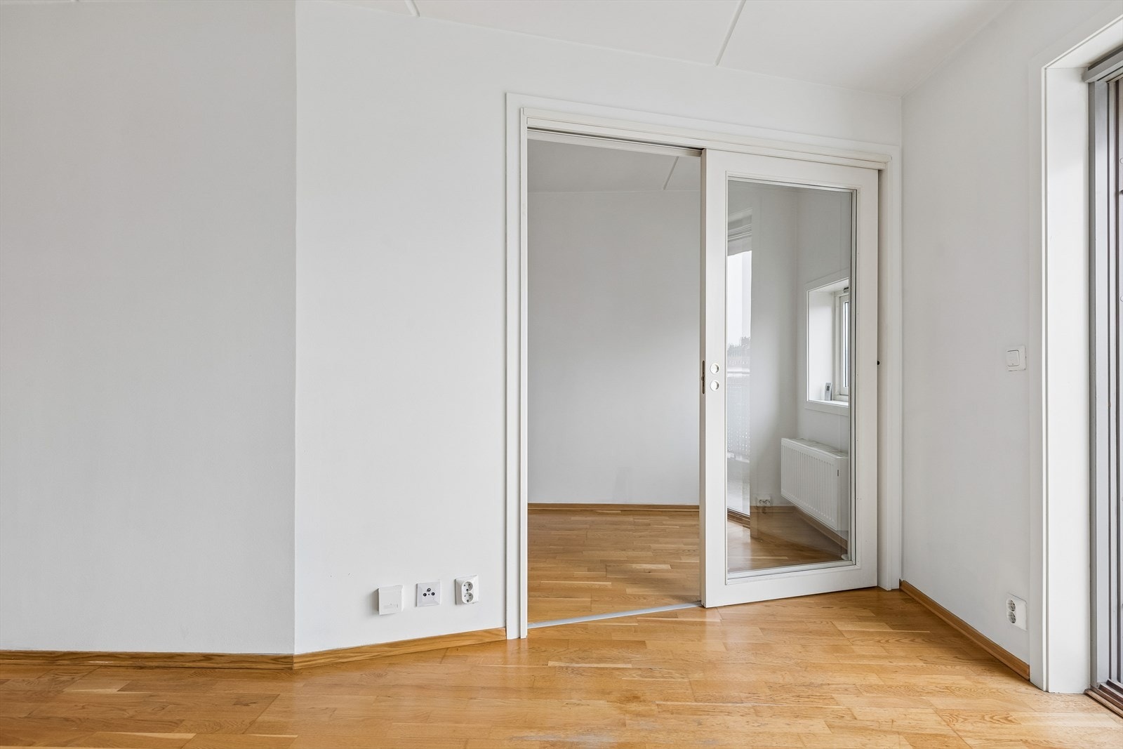 En skyvedør med glassfelt skiller stuen fra soverommet, noe som bevarer lyset og romfølelsen. Galleribilde