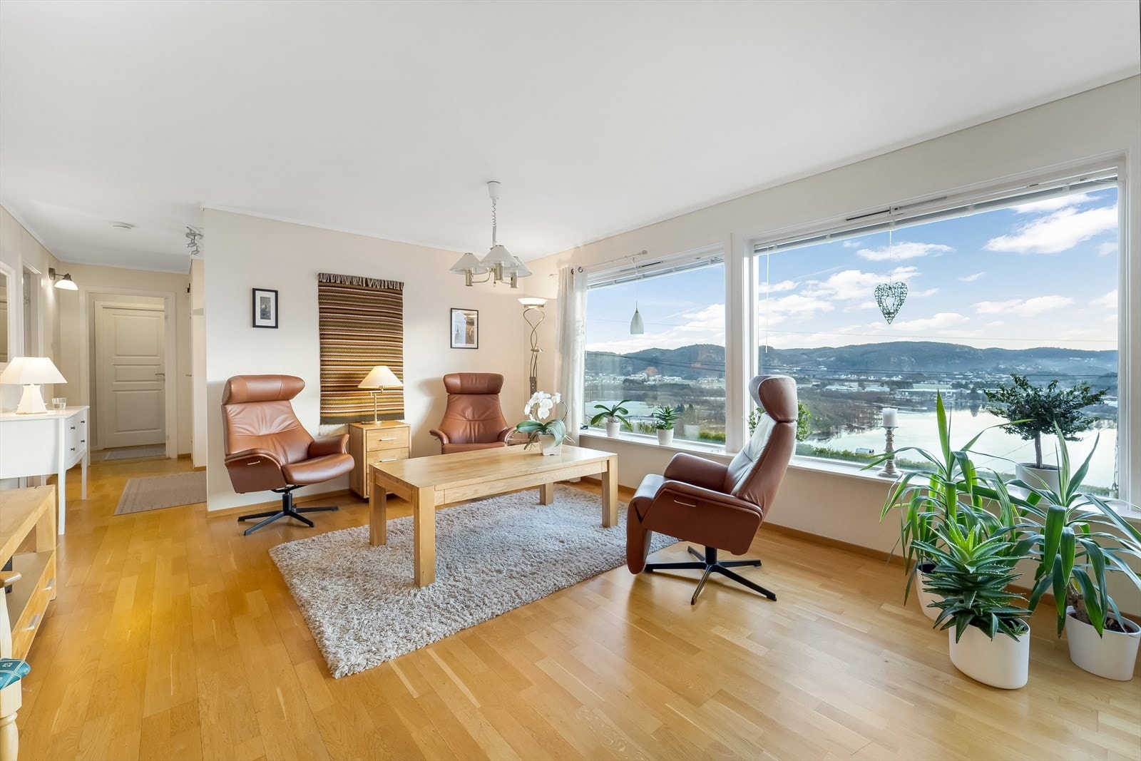 Store vindusflater i stua gir godt med lys inn og den flotte utsikten mot fjorden og elva kan nytes fra flere hold. Galleribilde