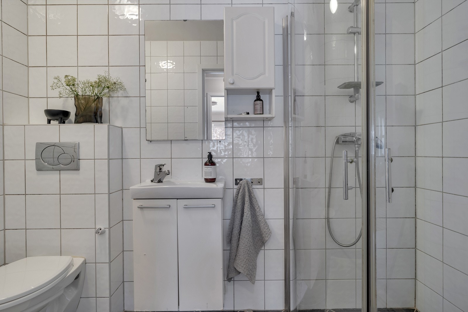 Flislagt bad med dusjhjørne, wc og servant med underskap og overspeil. Galleribilde