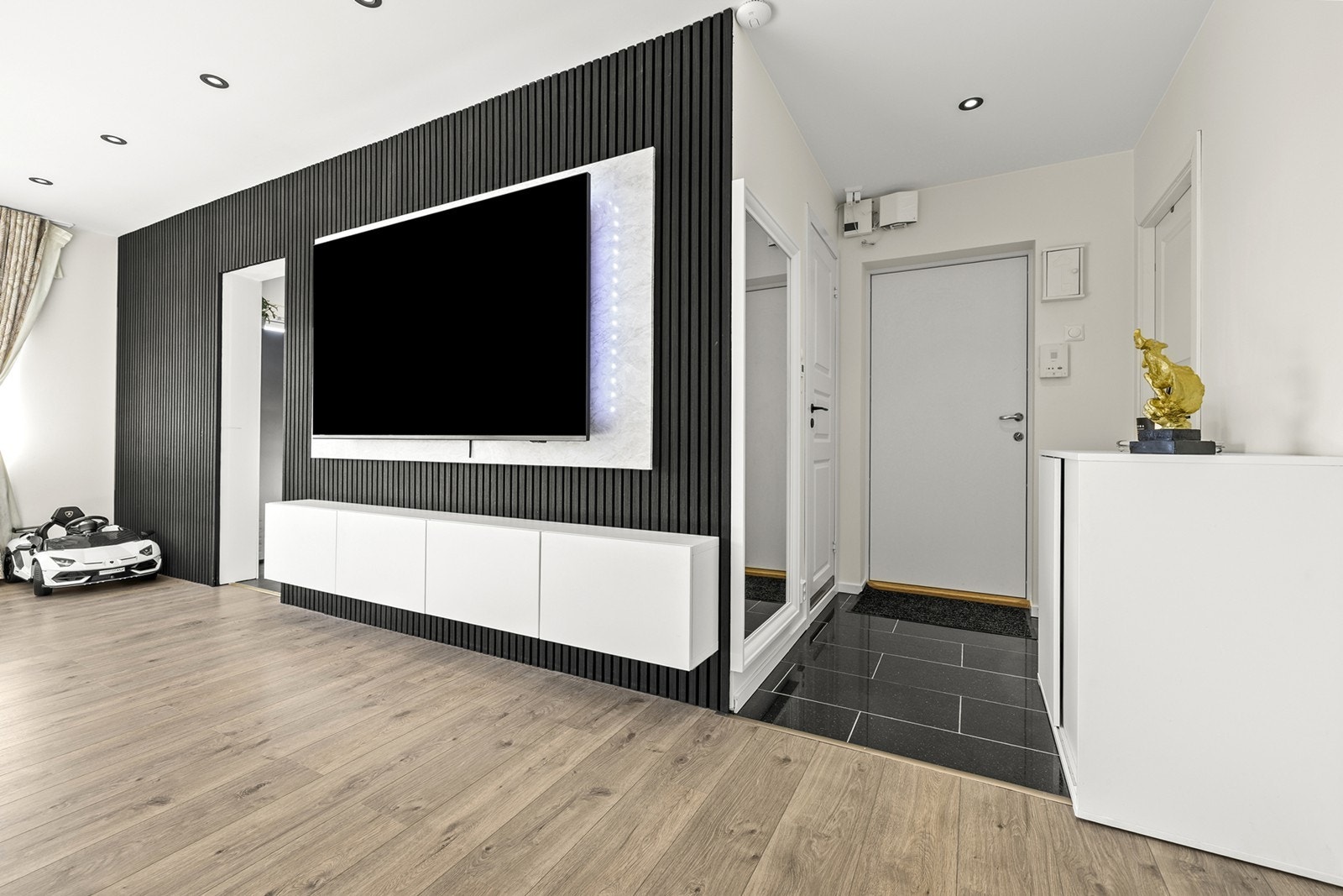 Vegger med listverk og integrert TV gir et moderne preg til oppholdsrommet. Galleribilde