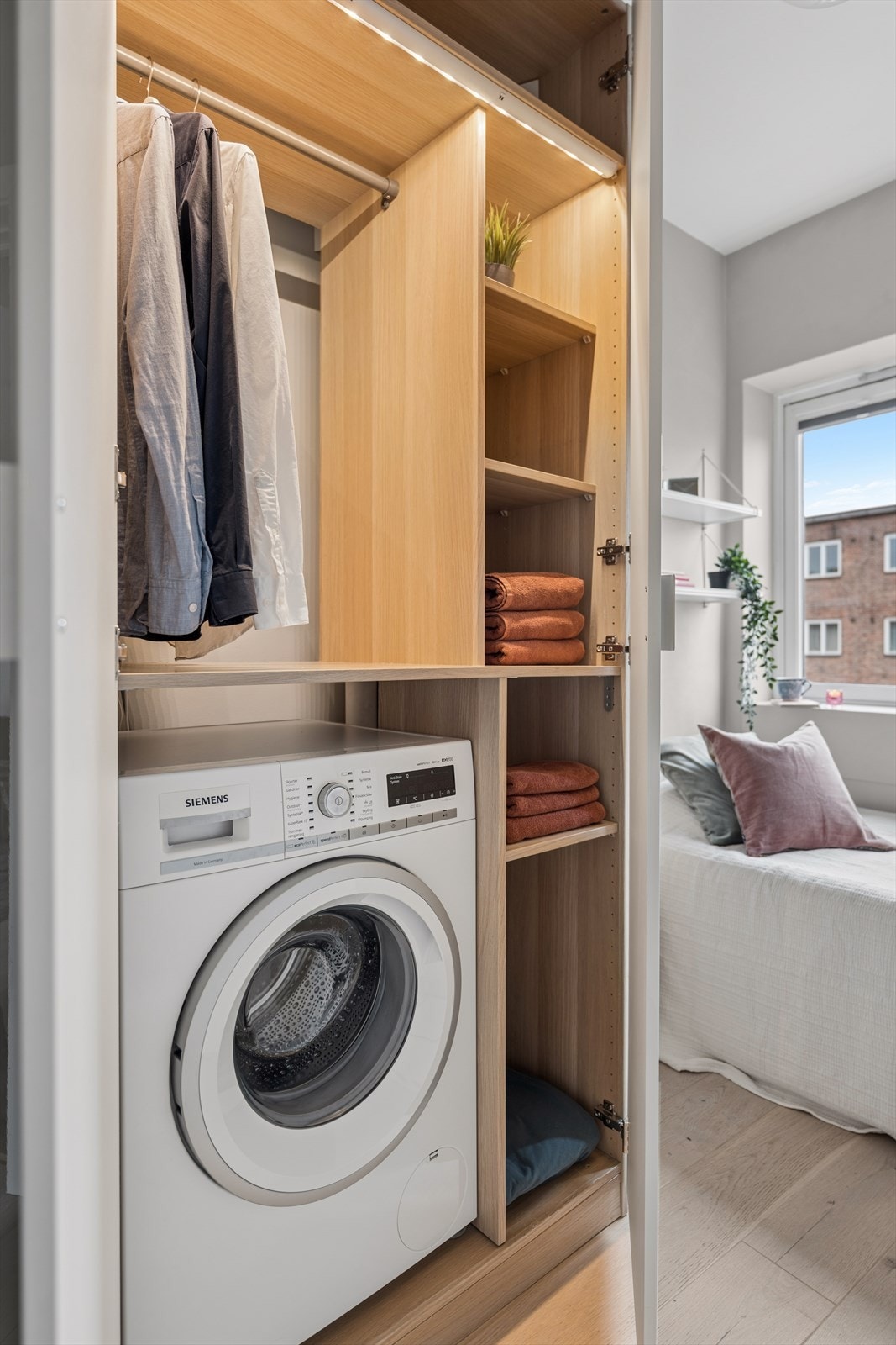 Her finner du også en praktisk garderobeløsning med innebygd oppbevaring og plass til vaskemaskin, noe som gjør rommet fleksibelt enten det brukes som barnerom, gjesterom eller kontor. Galleribilde