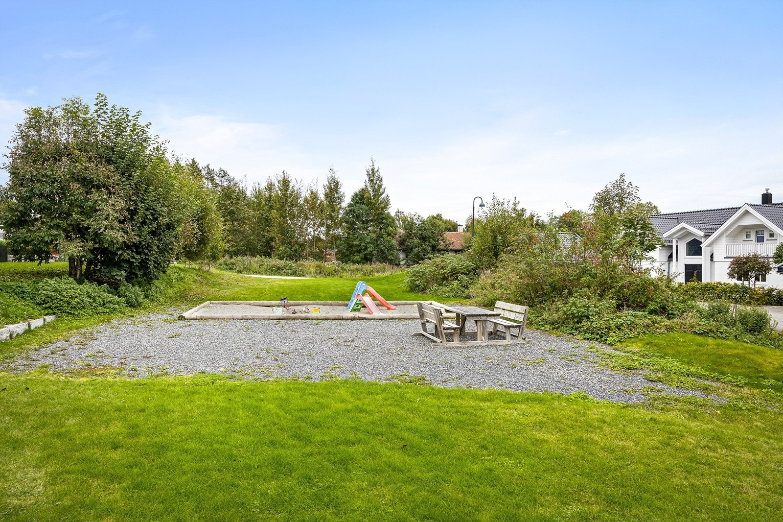 Et stort, felles grøntareal med lekeplass ligger rett i forkant av eiendommen. Galleribilde