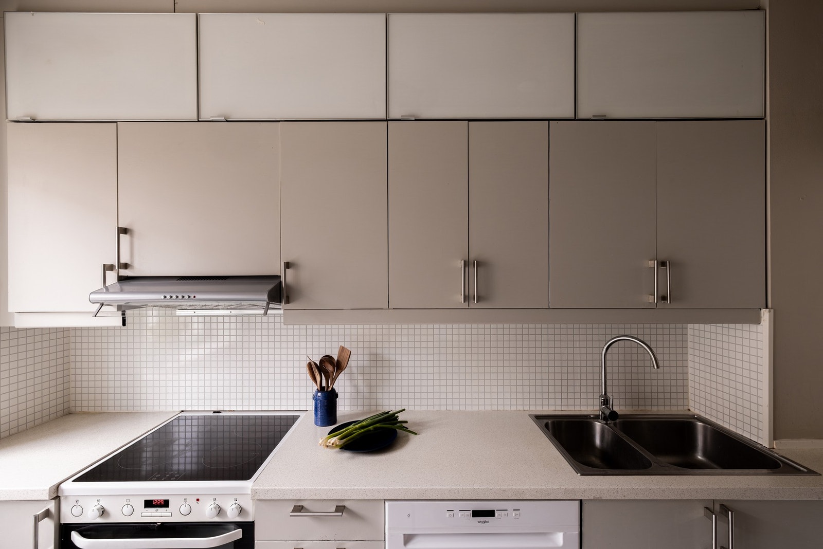 Pen og tidløs kjøkkeninnredning med med glatte fronter og benkeplate av laminat. Dobbel
oppvaskkum av rustfritt stål Galleribilde