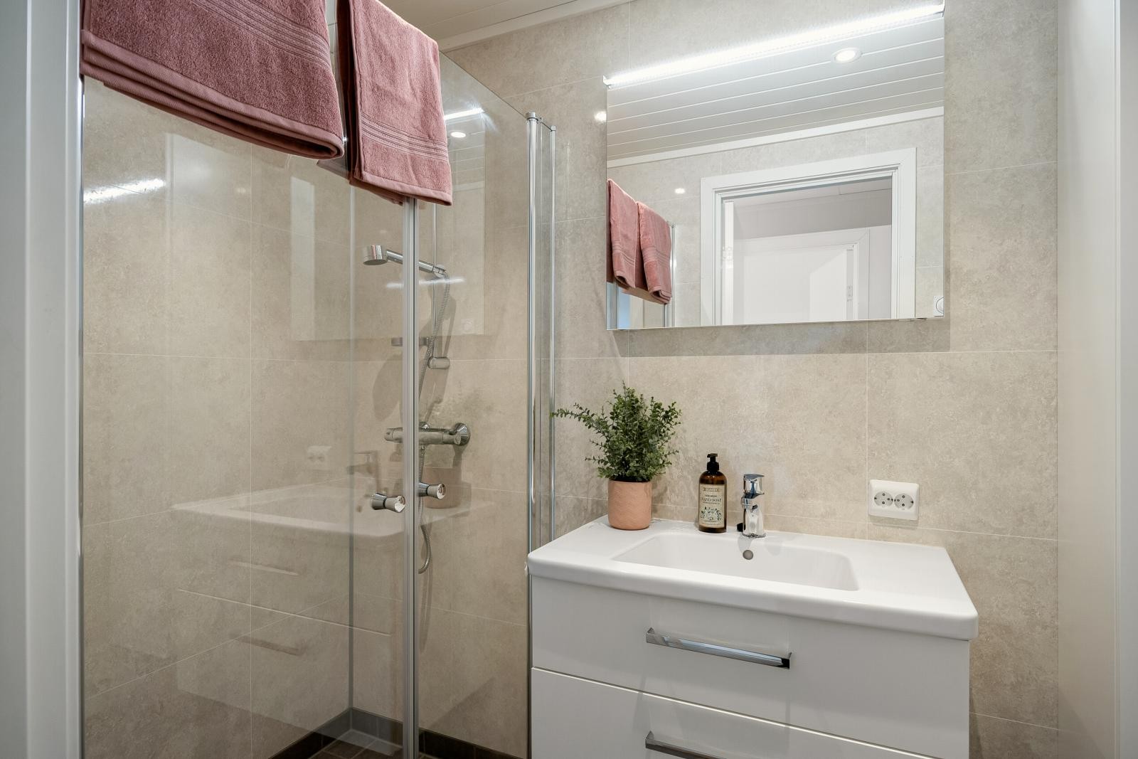 Badet i 2.etasje har tilbyr romslig dusjnisje, toalett, innredning og gulvvarme. Praktisk plassering med nærhet til alle soverom. Galleribilde