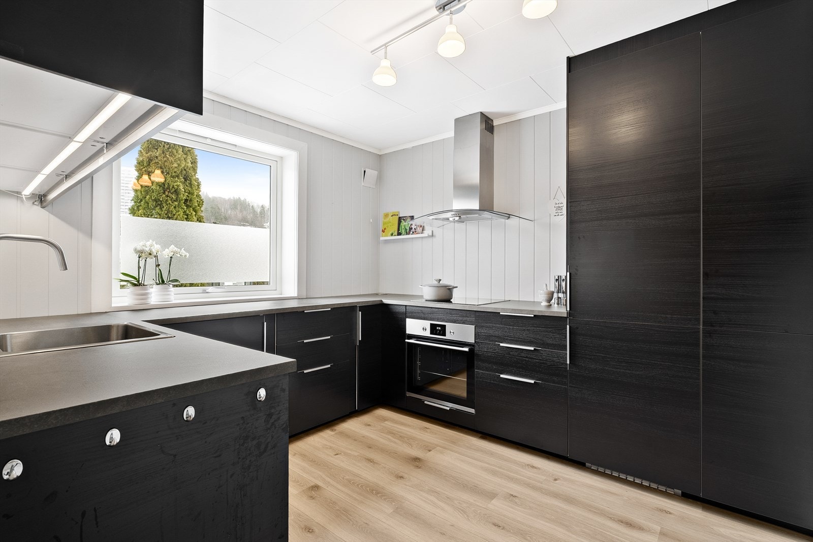 Moderne kjøkken i sort, med god skap og benkeplass for matlagingen. Galleribilde