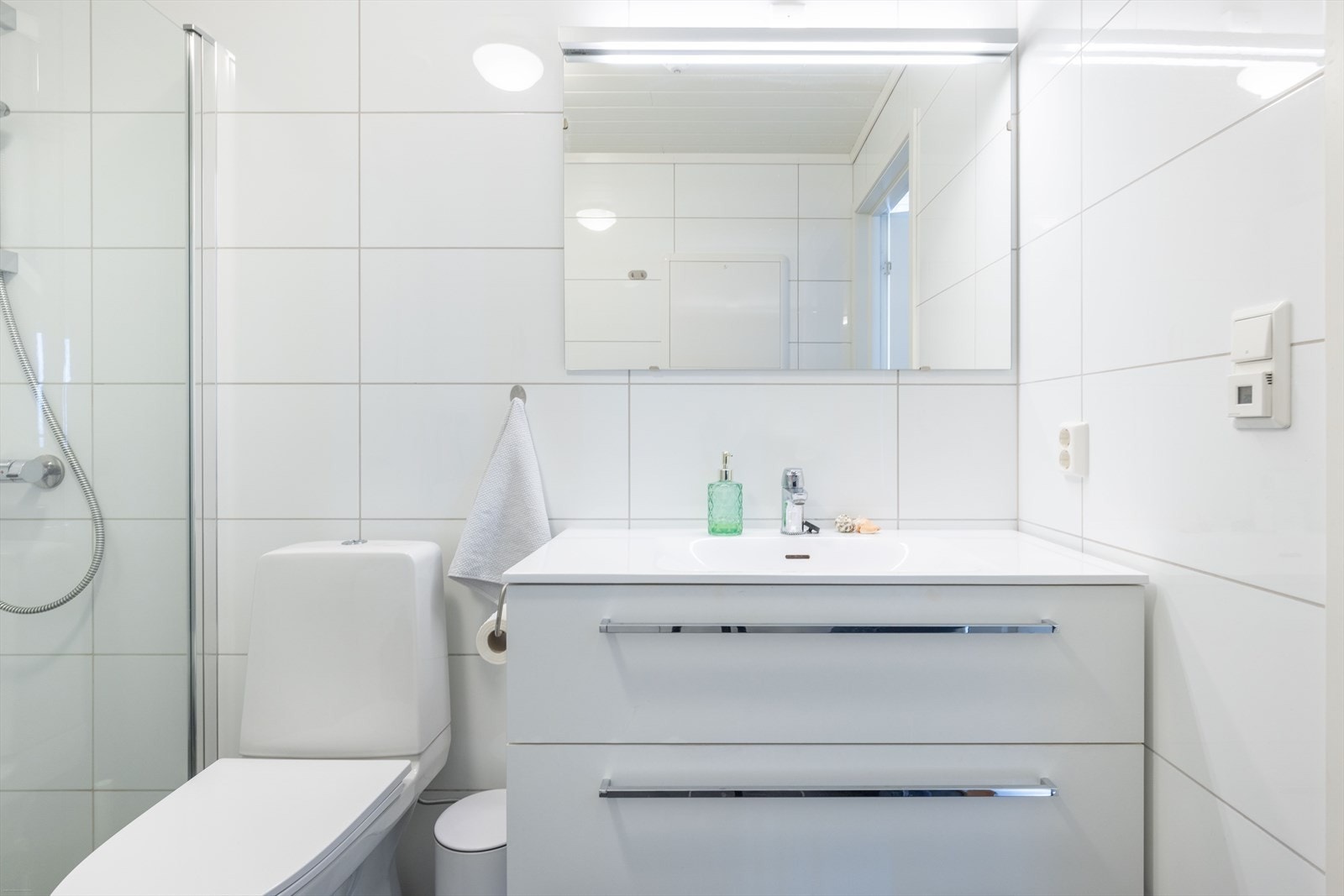 Det andre bader er romslig og er helfliset med servantinnredning, toalett og opplegg for vaskemaskin. Galleribilde