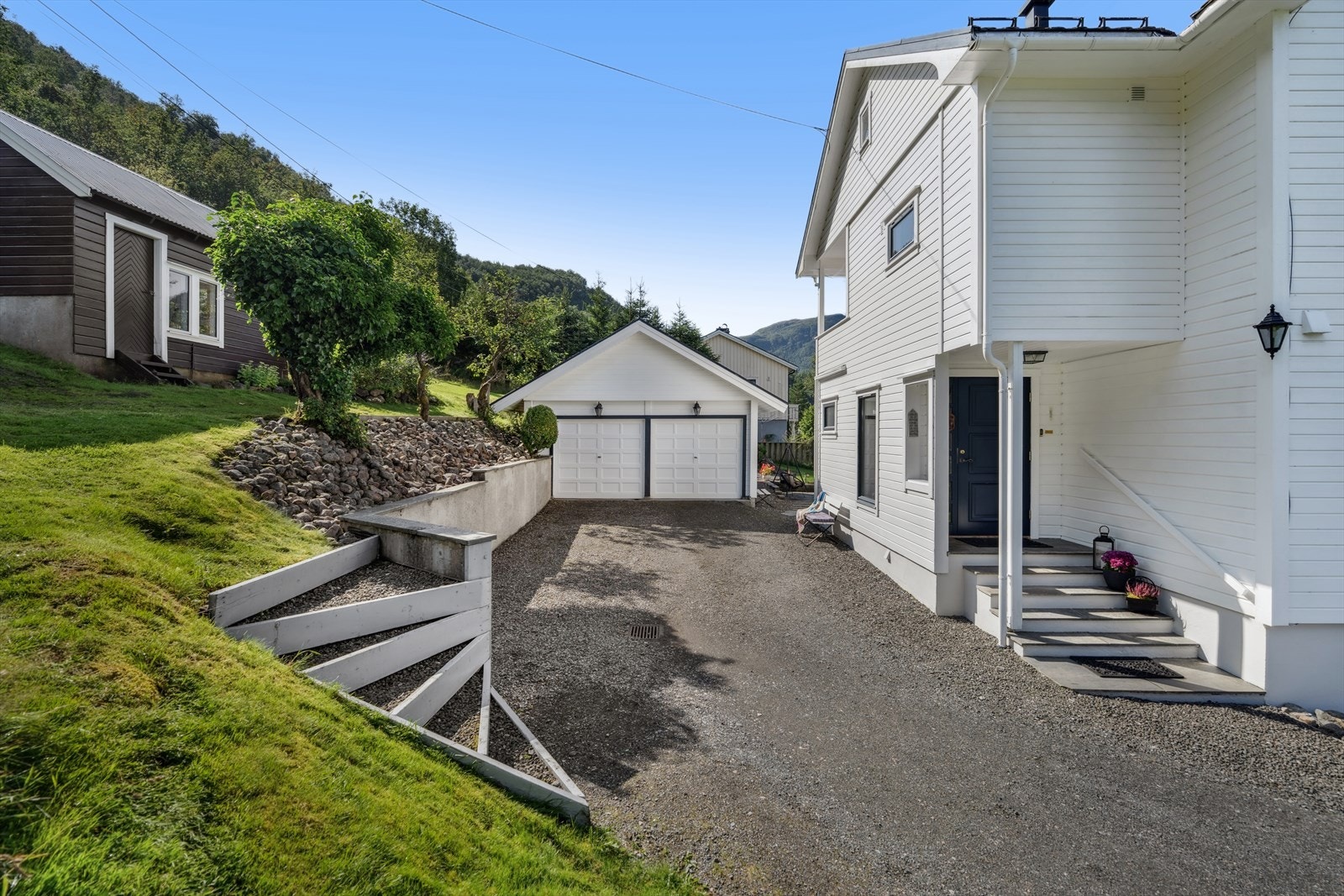 Til eiendommen hører en dobbelgarasje på 38 m² og et separat uthus for ekstra lagring. Galleribilde