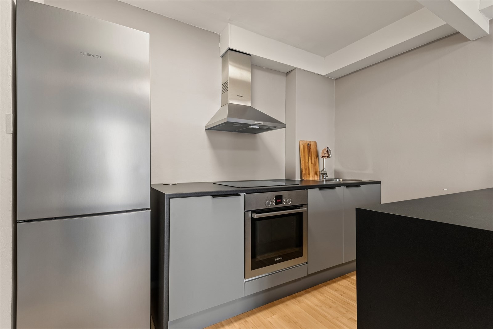 Kjøkkenet har en innredning fra 2021 med slette fronter, laminat benkeplate og kjøkkenøy. Galleribilde