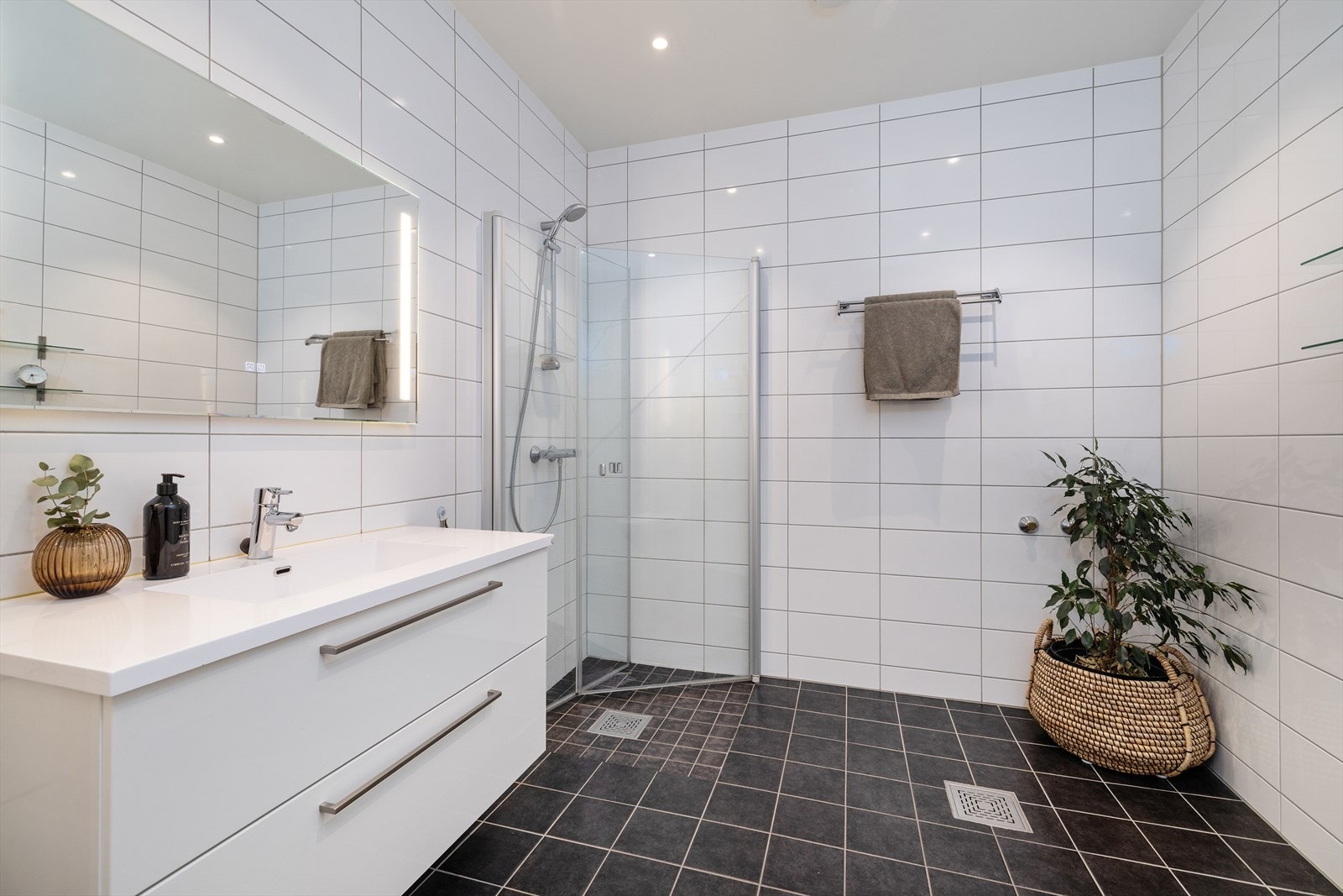 Badet er utstyrt med dusjhjørne med glassdører og har opplegg for badekar. Galleribilde