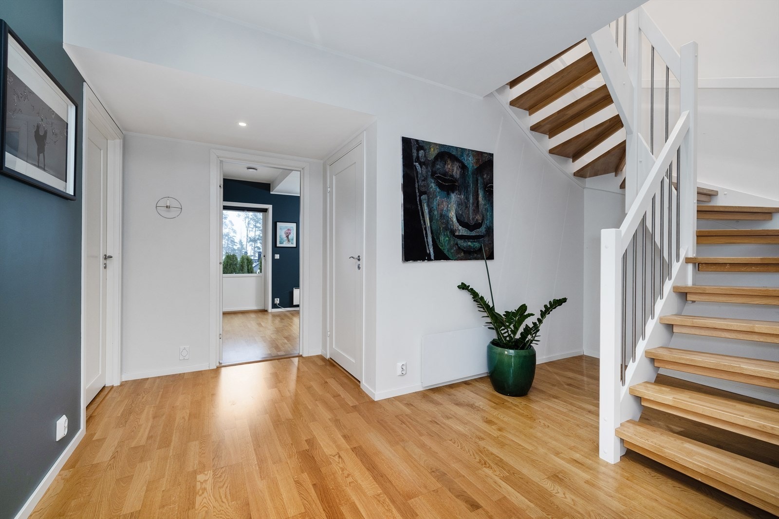 Den elegante trappen med inntrinn av eik forbinder boligens to etasjer. Galleribilde