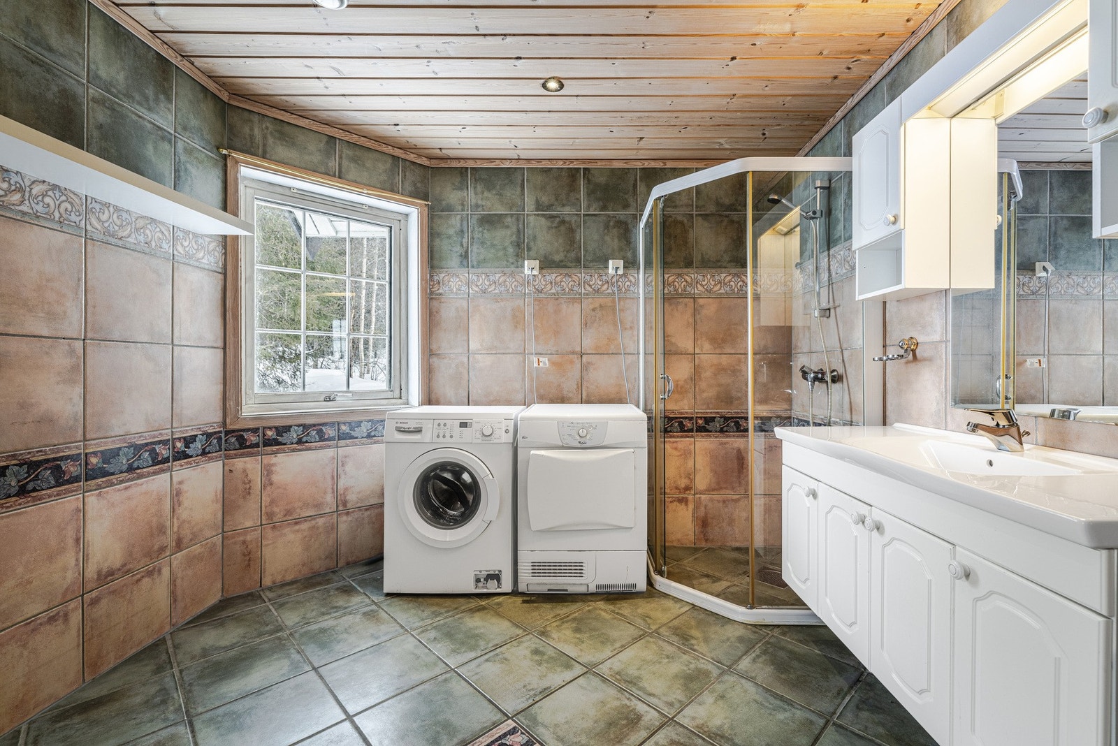 Dusjnisje og opplegg for vaskemaskin og tørketrommel på hovedbad. Galleribilde