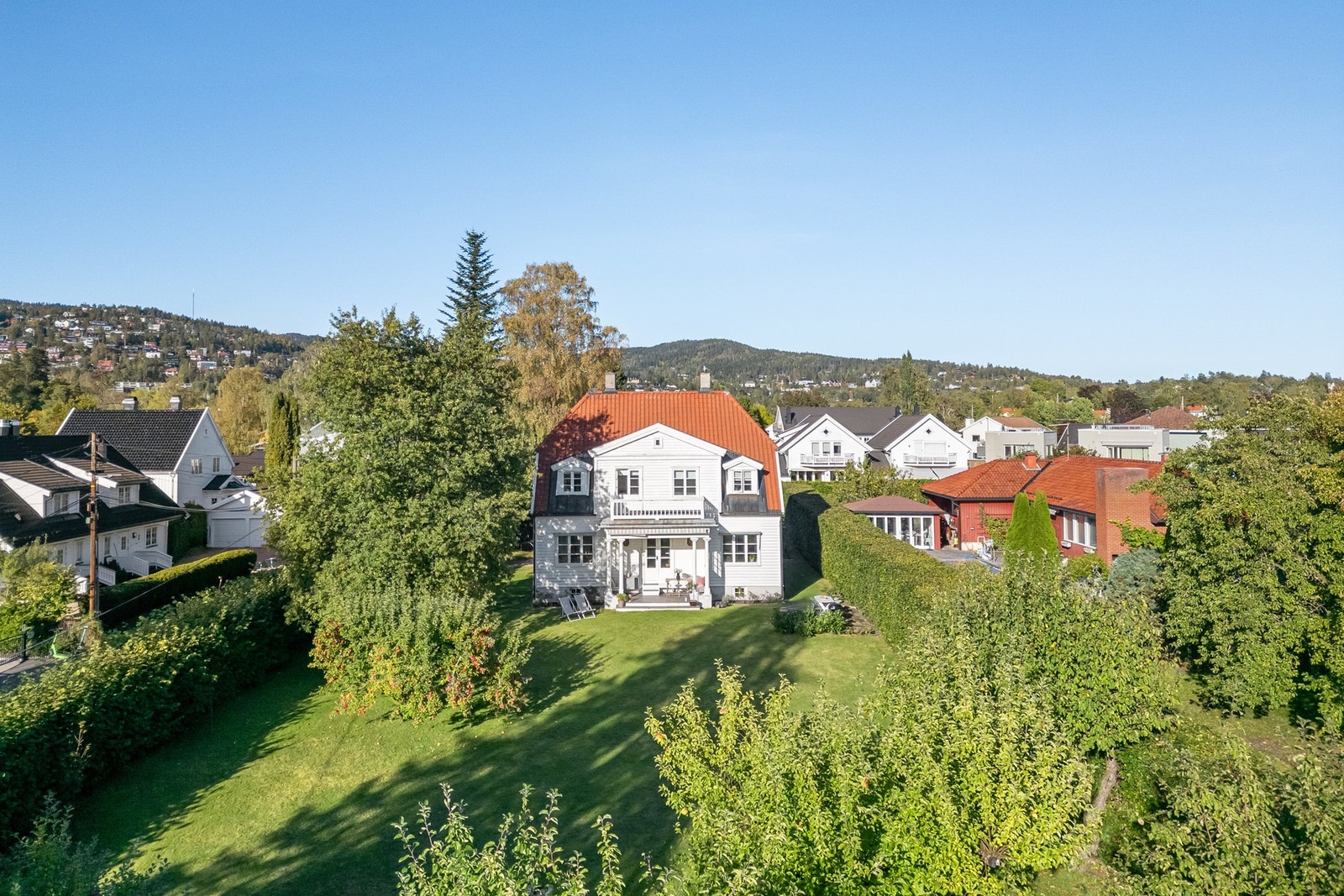 Tomten er pent opparbeidet med hekk og diverse beplantning. Galleribilde