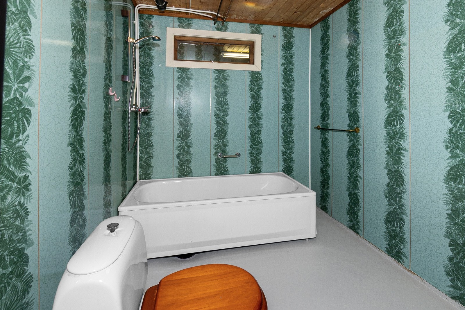 Bad i kjeller med badekar/dusj på vegg, wc og servant. Galleribilde