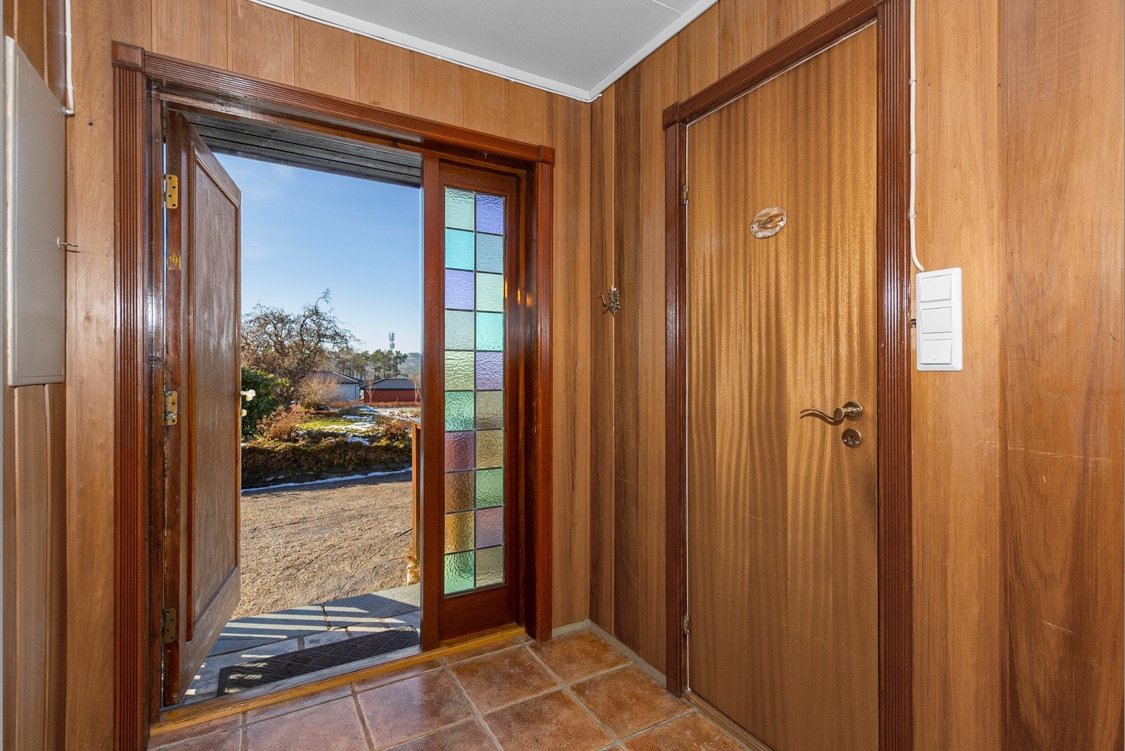 Flislagt vindfang. Dør til høyre inn til toalettrom. Galleribilde