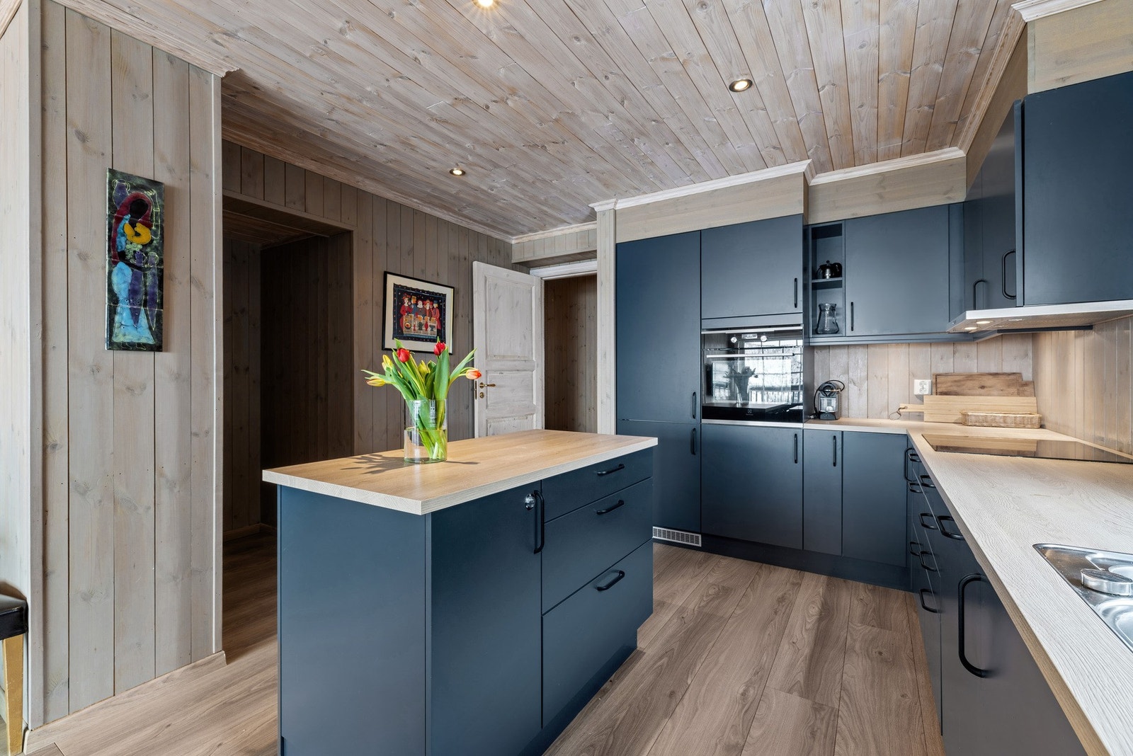 Hvitevarene er integrert i innredningen og består av platetopp, stekeovn, oppvaskmaskin samt kjøleskap med fryserdel. Galleribilde