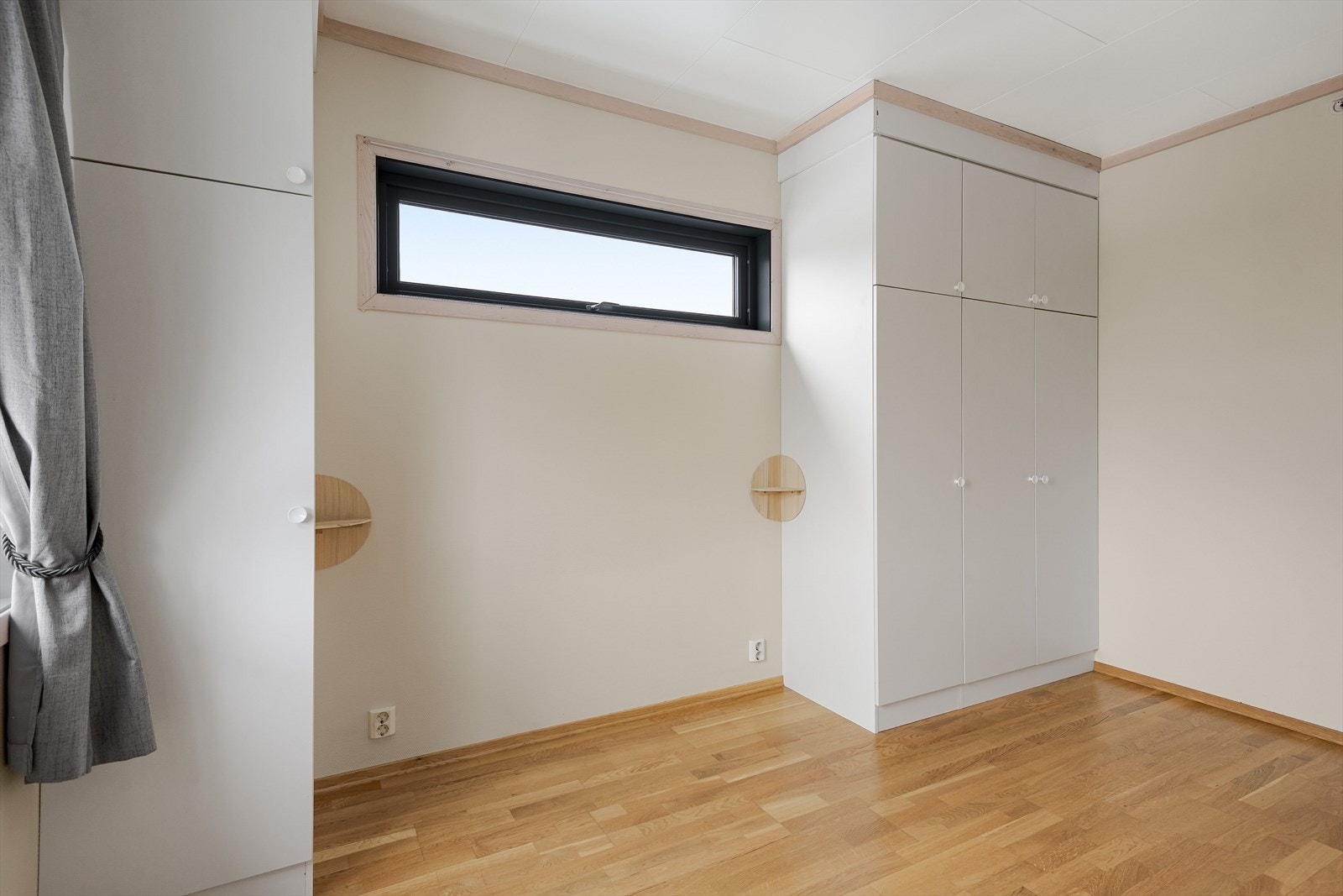 Skyvedørsgarderobe på hver side med plass til seng i mellom. Galleribilde