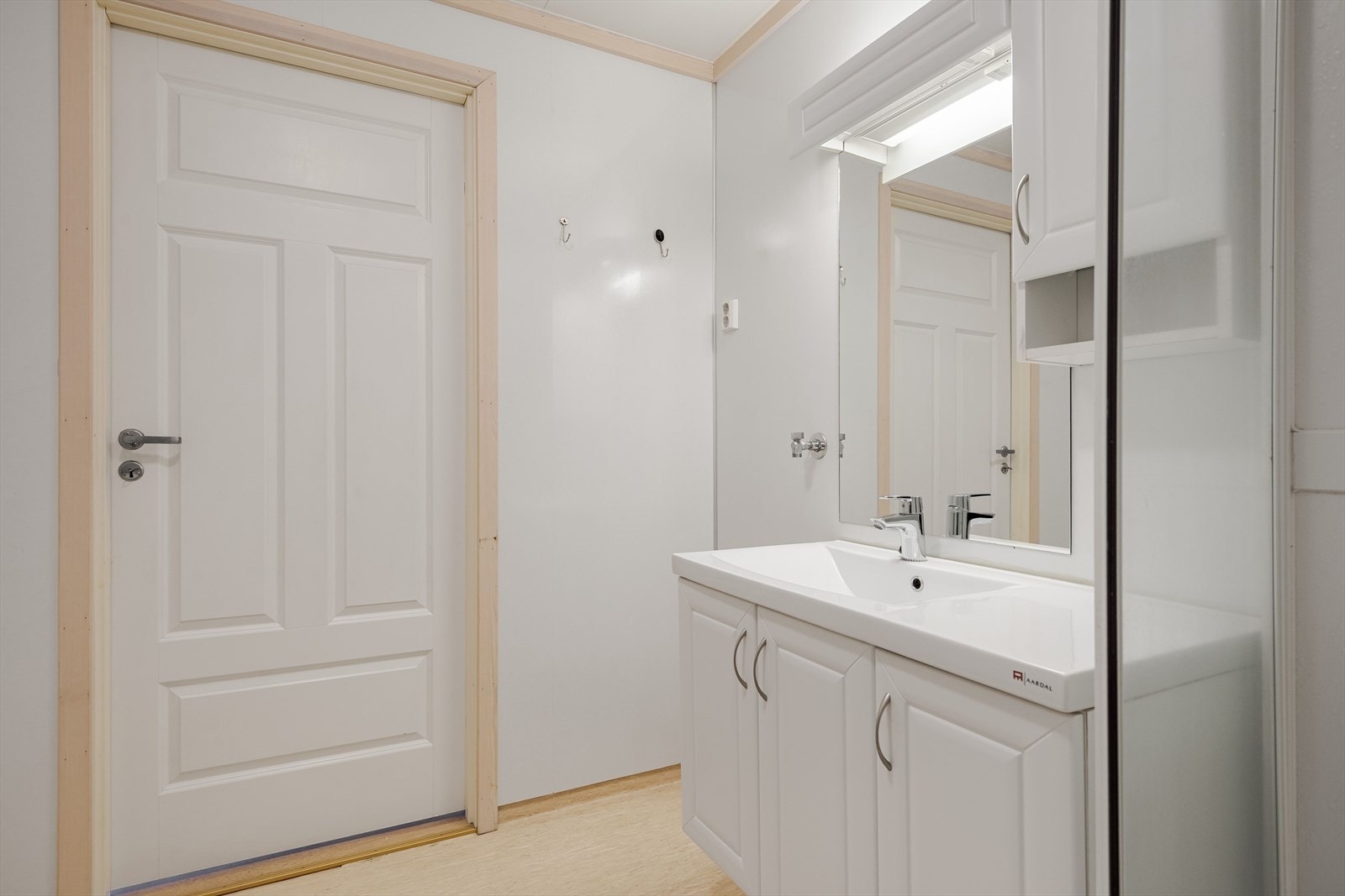 Vinylbelegg på gulvet med elektriske varmekabler og baderomsplater på veggene. Galleribilde