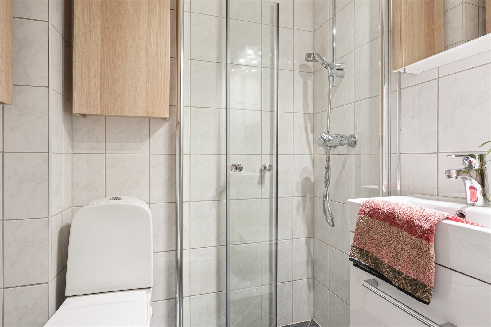 Helfliset bad på 1,8m² med wc, dusjsone og servant med oppbevaringsplass. Galleribilde