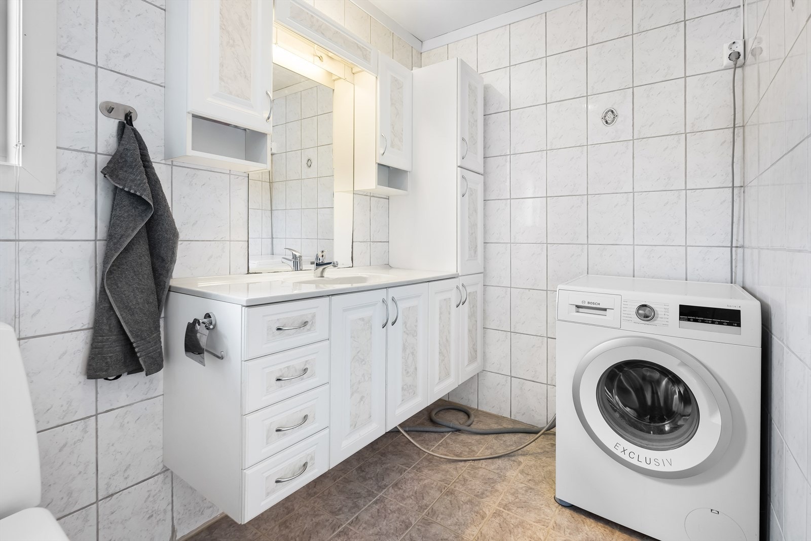 Badet er helfliset med varme i gulvet. Lyse fliser på veggene og gråbeige på gulv. Galleribilde