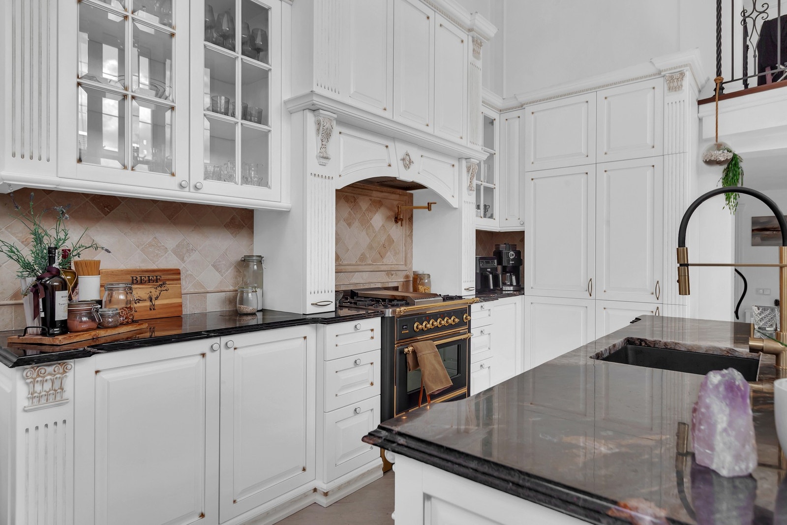 Her er det ikke spart på detaljene med benkeplate i stein, integrerte hvitevarer, elektrisk komfyr med gassbluss og kran med kokende vann plassert over. Galleribilde