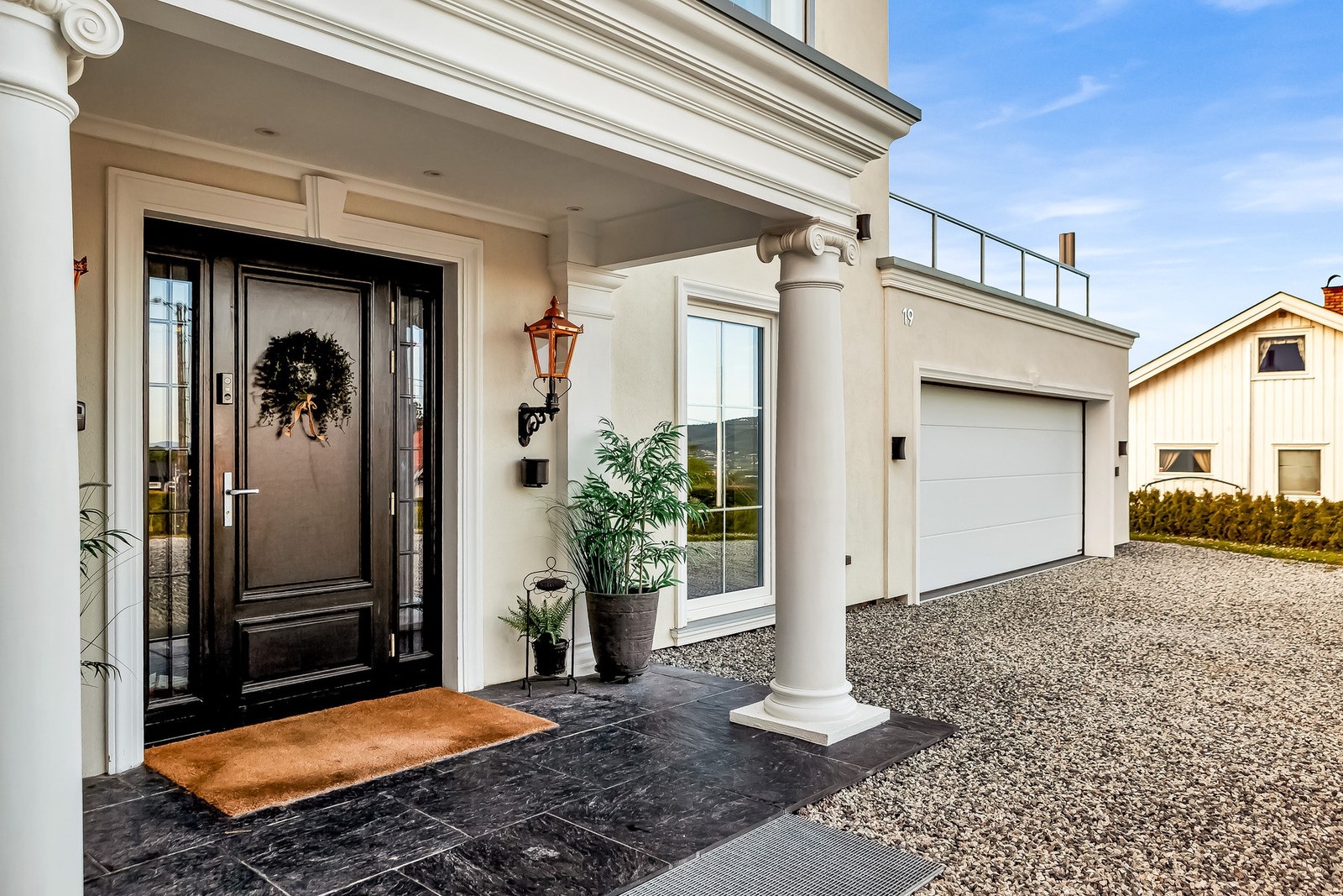 Velkommen! Her får man et herskapelig førsteinntrykk med den profilerte ytterdøren og bærende søyler. Galleribilde