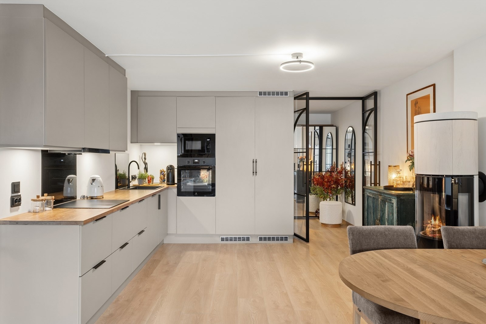 Stilrent og moderne kjøkken med åpen løsning til stuen med integrerte hvitevarer og god arbeidsplass. Galleribilde