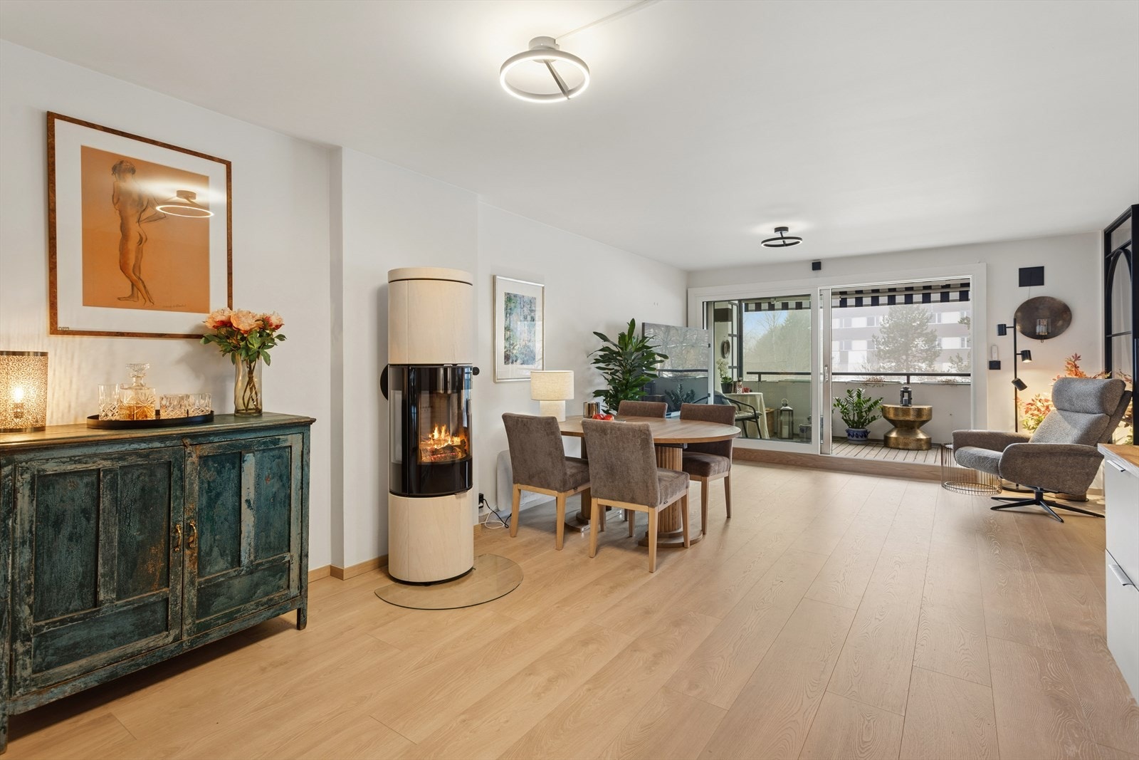 Det er lys og åpen løsning mellom kjøkken og stue med møbleringsalterativer. Galleribilde