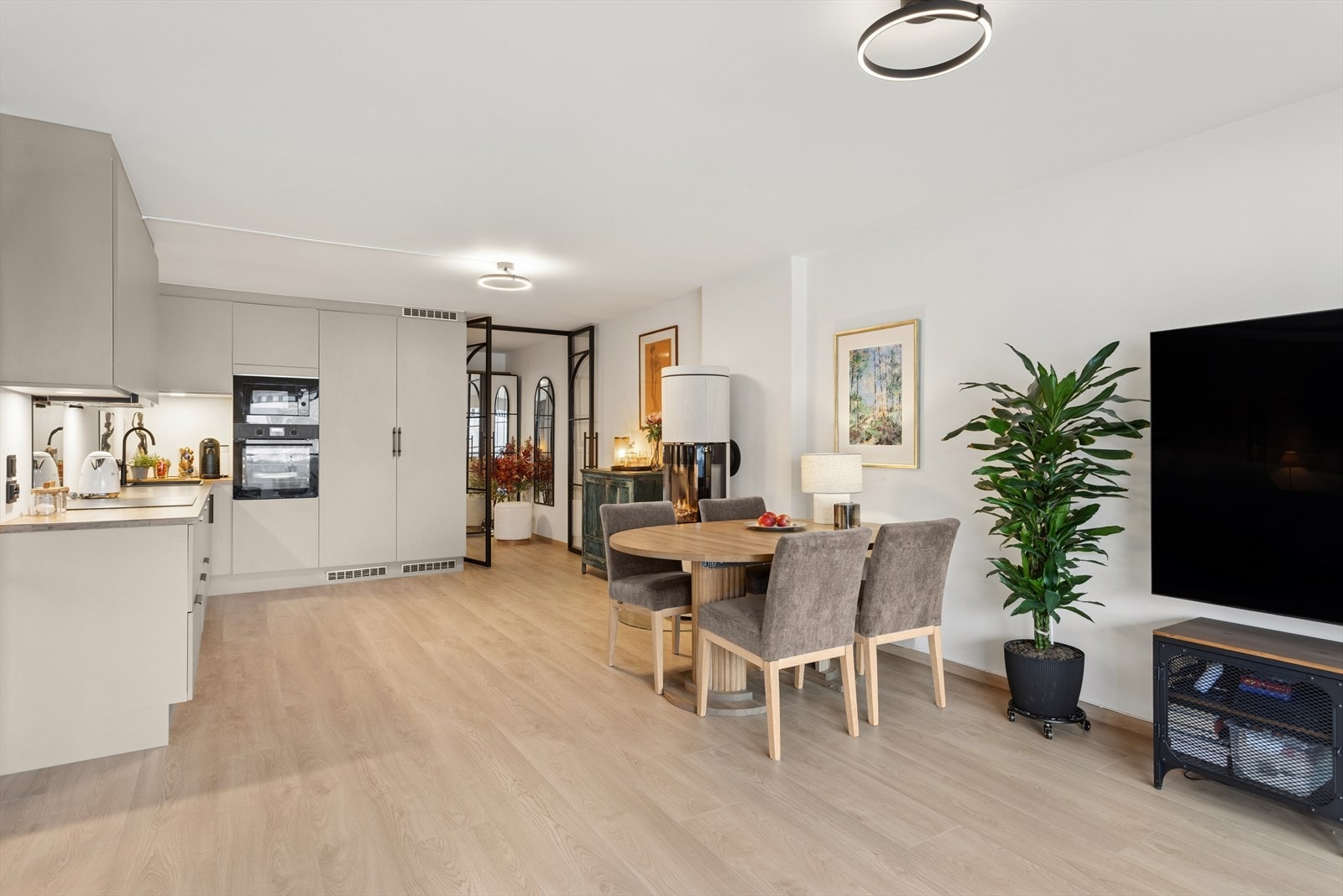 Det er en lys og romslig stue med åpen kjøkkenløsning. Galleribilde