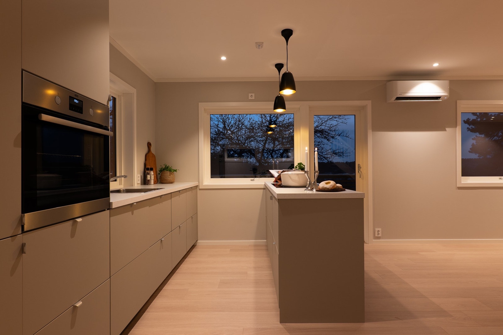 Arbeids- og avlastningsflater rundt både vask og platetopp gjør kjøkkenet effektivt. Stekeovnen er montert i praktisk benkehøyde. Galleribilde