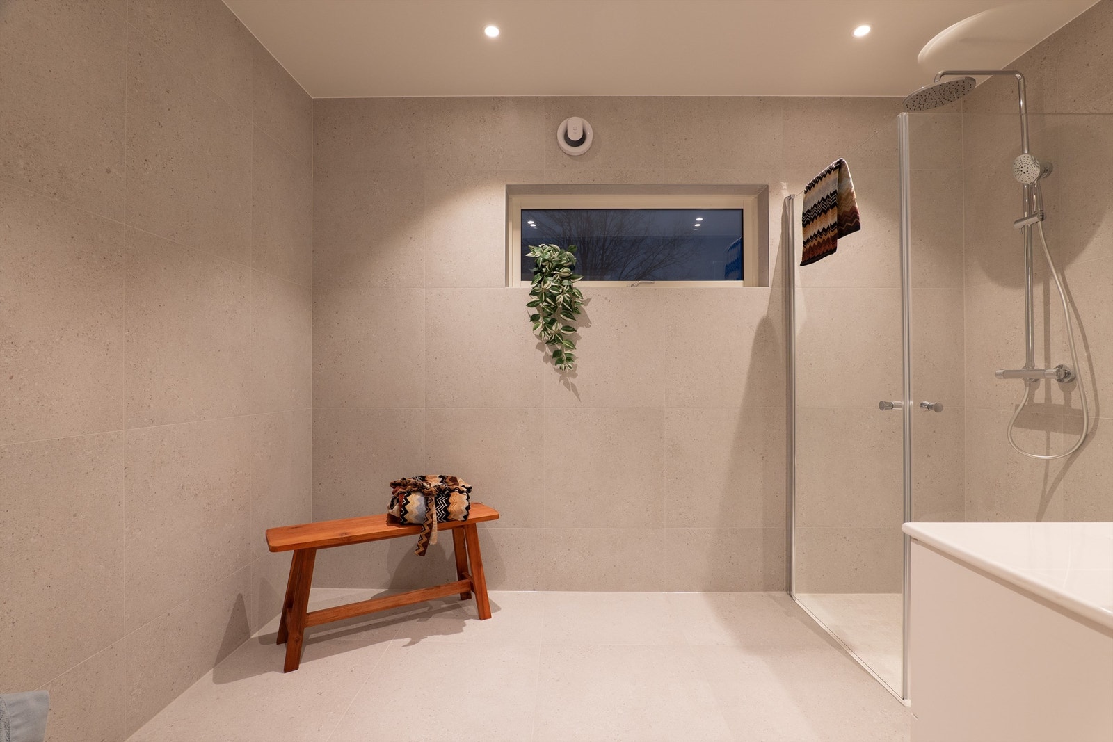 Terrazzofliser av 60x60 cm. format på gulv og vegger skaper helhet. I gulvet er det elektrisk varme. Galleribilde