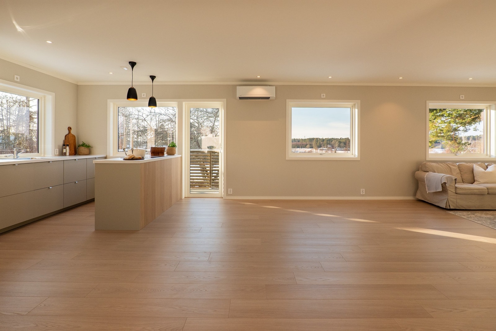 Stuen, spisestuen og kjøkkenet er sømløst forbundet i en stor sosial sone som utgjør det meste av første etasje. Galleribilde