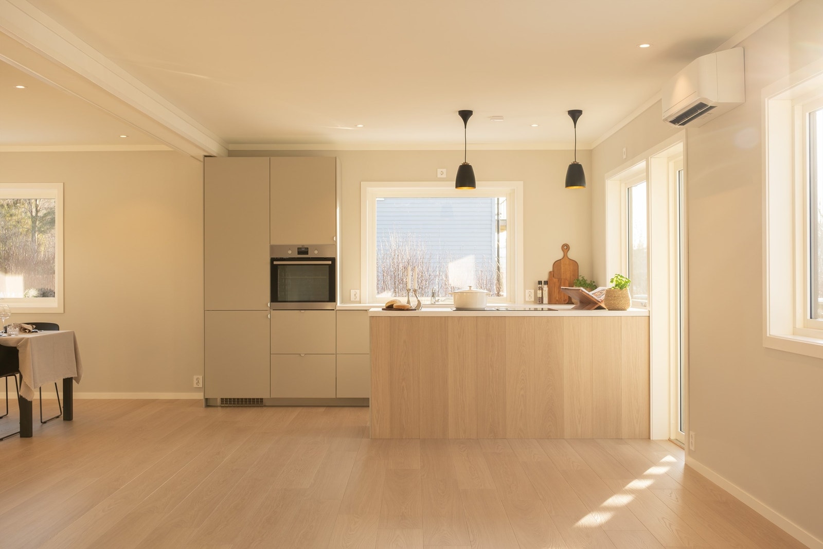 Laminat på øyens front fremmer en visuelt myk overgang og gjør kjøkkeninnredningen mindre fremtredende. Galleribilde