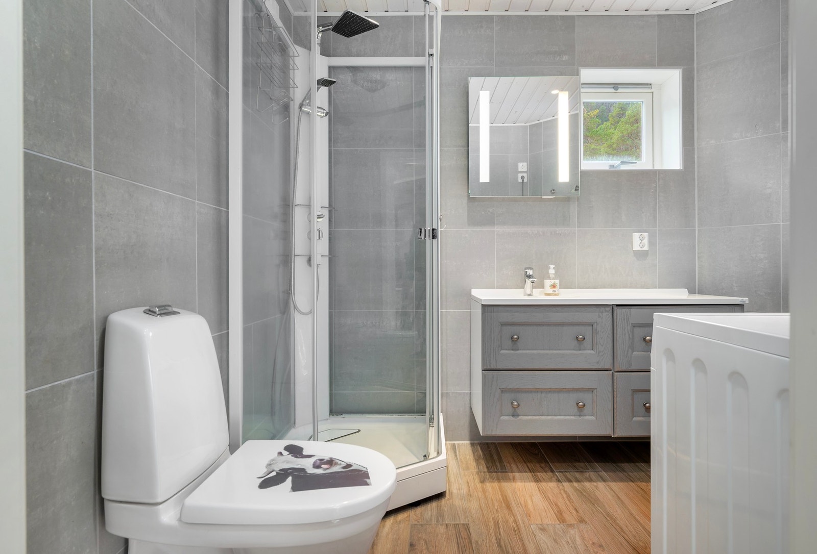 Badet er utstyrt med dusjkabinett, servant og wc. Galleribilde