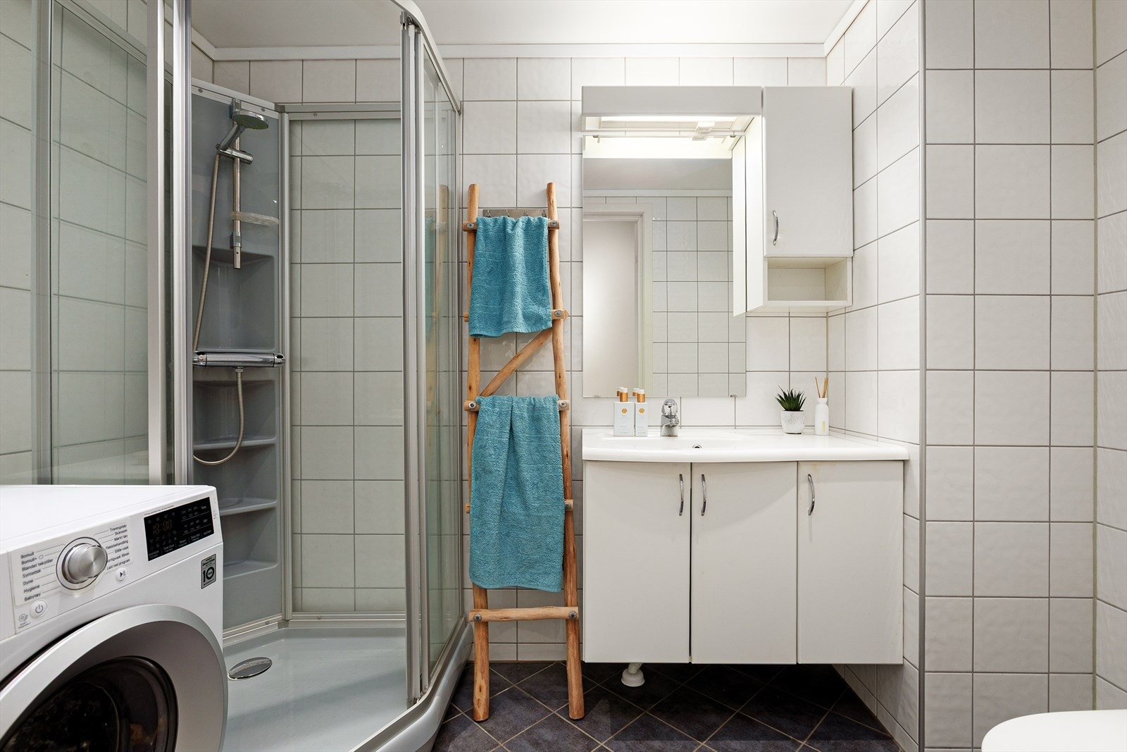 Praktisk og lyst bad med opplegg for vaskemaskin. Galleribilde